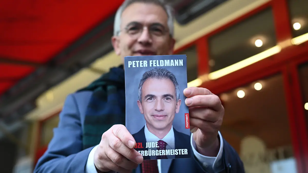 09.12.2022, Hessen, Frankfurt/Main: Peter Feldmann (SPD), abgewählter Frankfurter Oberbürgermeister, präsentiert vor dem Café Mozart seine Autobiografie mit dem Titel «Sozi. Jude. Oberbürgermeister». Das Buch erscheint am 14. Dezember 2022 im Frankfurter Nomen-Verlag. Der 64-Jährige wurde am 6. November nach diversen Skandalen bei einem Bürgerentscheid aus dem Amt gewählt. Seit 18. Oktober steht Feldmann zudem vor Gericht. (zu dpa ·Frankfurts Ex-Oberbürgermeister stellt Autobiografie vor·) Foto: Arne Dedert/dpa +++ dpa-Bildfunk +++