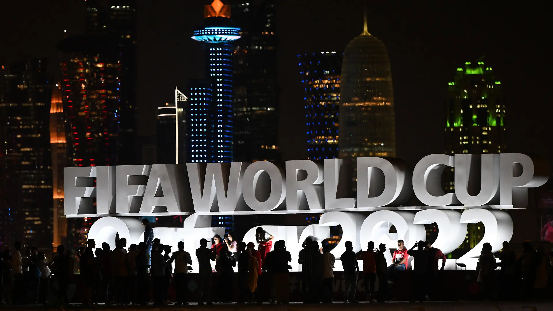 ARCHIV - 16.11.2022, Katar, Doha: Fans machen vor dem Schriftzug ·FIFA World Cup Qatar 2022·. Fotos. Israelische Journalisten berichten von Anfeindungen in Katar. (zu dpa: «Israelische Journalisten berichten von Anfeindungen bei WM in Katar») Foto: Federico Gambarini/dpa +++ dpa-Bildfunk +++