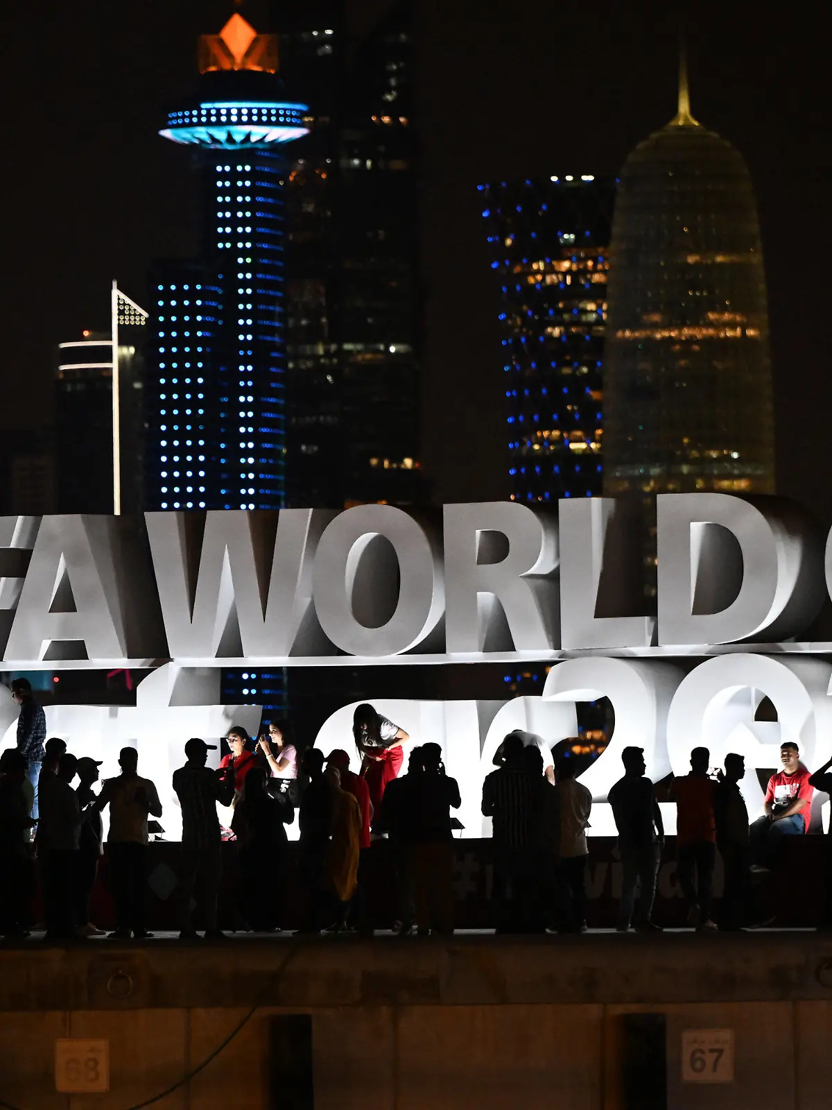 ARCHIV - 16.11.2022, Katar, Doha: Fans machen vor dem Schriftzug ·FIFA World Cup Qatar 2022·. Fotos. Israelische Journalisten berichten von Anfeindungen in Katar.  (zu dpa: «Israelische Journalisten berichten von Anfeindungen bei WM in Katar») Foto: Federico Gambarini/dpa +++ dpa-Bildfunk +++