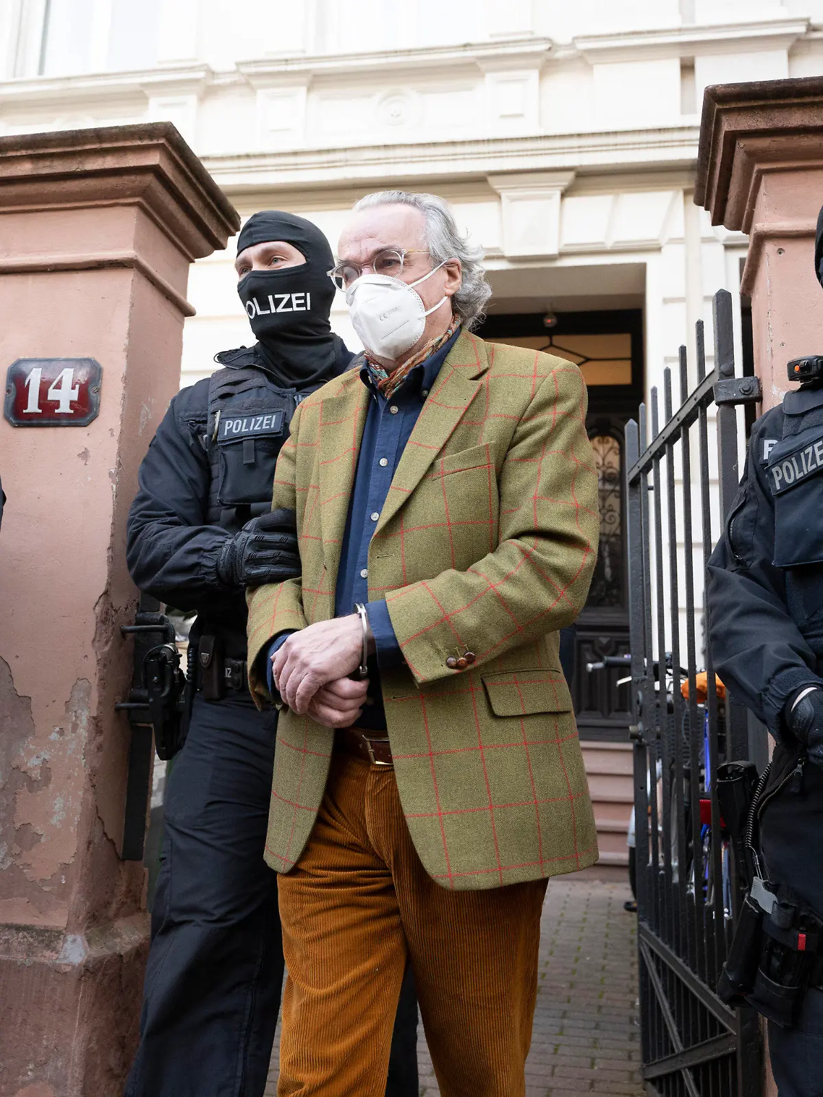 dpatopbilder - 07.12.2022, Hessen, Frankfurt/Main: Bei einer Razzia gegen sogenannte «Reichsbürger» führen vermummte Polizisten, nach der Durchsuchung eines Hauses Heinrich XIII Prinz Reuß (2.v.r.) zu einem Polizeifahrzeug. Die Bundesanwaltschaft hat am Mittwochmorgen mehrere Menschen aus der sogenannten Reichsbürgerszene im Zuge einer Razzia festnehmen lassen. Zahlreiche Beamte seien in mehreren Bundesländern im Einsatz, sagte eine Sprecherin der Karlsruher Behörde . Foto: Boris Roessler/dpa +++ dpa-Bildfunk +++