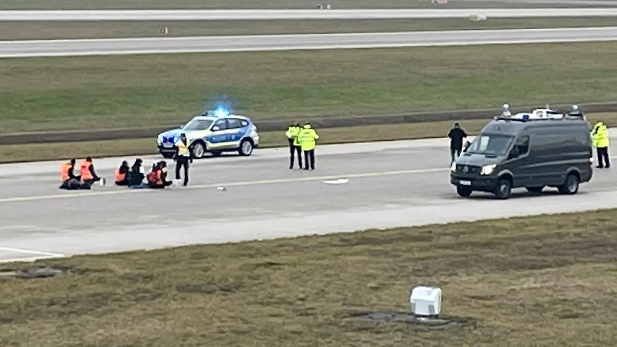 Activists of "Letzte Generation" (Last Generation) glued themselves to the tarmac of the airport to protest for a speed limit on highways as well as for affordable public transport, in Munich, Germany, December 8, 2022. REUTERS/Anja Guder