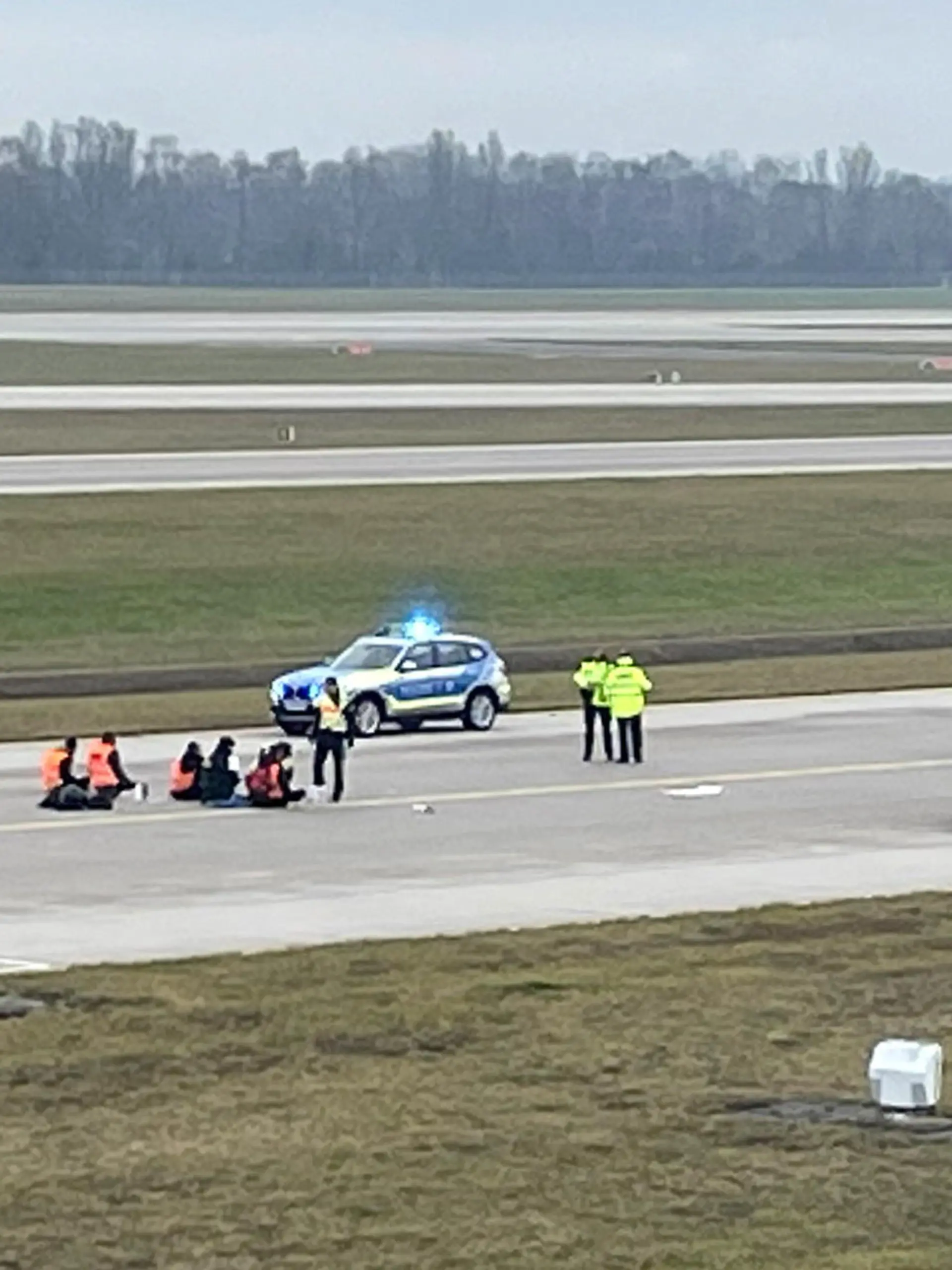 Activists of "Letzte Generation" (Last Generation) glued themselves to the tarmac of the airport to protest for a speed limit on highways as well as for affordable public transport, in Munich, Germany, December 8, 2022. REUTERS/Anja Guder