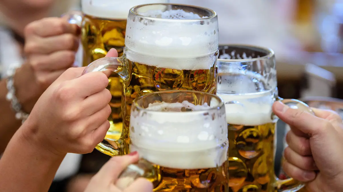 ARCHIV - 21.09.2019, Bayern, München: Besucher stoßen auf dem Oktoberfest mit Bier an. Zum ersten Mal seit Beginn der Corona-Pandemie kommt das Oktoberfest zurück. Gefeiert werden soll das weltgrößte Volksfest vom 17. September bis zum 3. Oktober - ohne Corona-Auflagen. (zu dpa: «Bier, Zelt - Flirt? Die Wiesn und ihre Tücken») Foto: Matthias Balk/dpa +++ dpa-Bildfunk +++