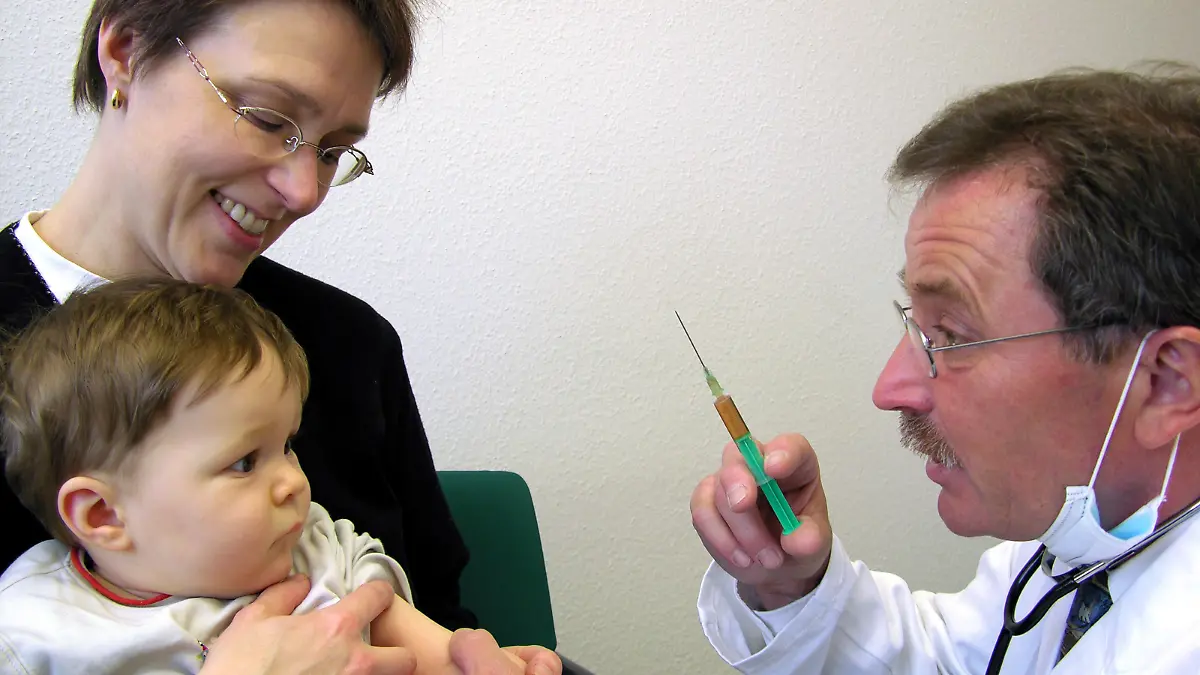 Ein Arzt mit Spritze versucht, dem Baby die Angst vor dem Pickser zu nehmen, aufgenommen am 06.03.2005 in Stuttgart. Foto: Jürgen Effner +++(c) dpa - Report+++
