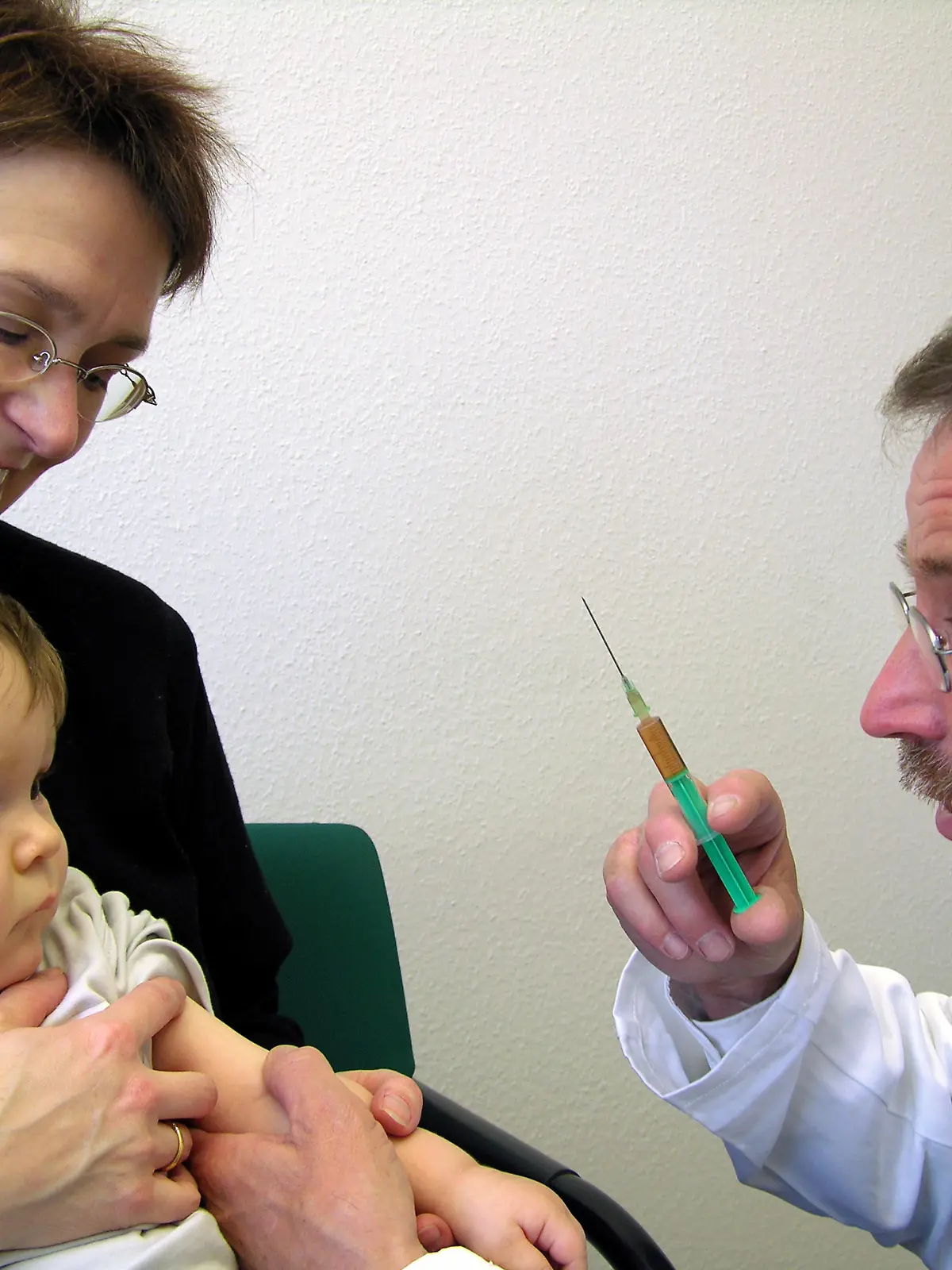 Ein Arzt mit Spritze versucht, dem Baby die Angst vor dem Pickser zu nehmen, aufgenommen am 06.03.2005 in Stuttgart. Foto: Jürgen Effner +++(c) dpa - Report+++