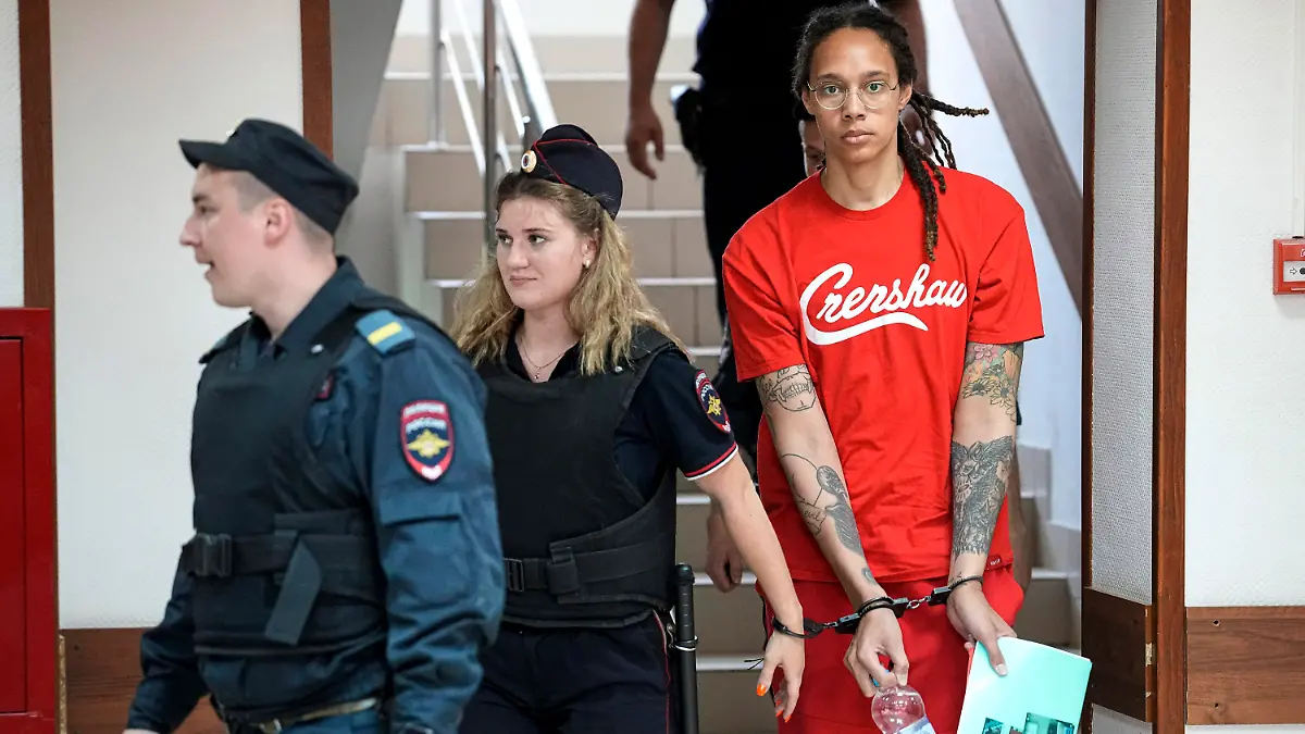 FILE - WNBA star and two-time Olympic gold medalist Brittney Griner is escorted to a courtroom for a hearing in Khimki just outside Moscow, on July 7, 2022. Russia has freed WNBA star Brittney Griner on Thursday in a dramatic high-level prisoner exchange, with the U.S. releasing notorious Russian arms dealer Viktor Bout. (AP Photo/Alexander Zemlianichenko, File)