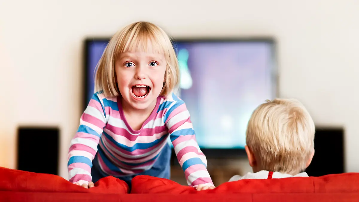 While her big brother watches television, this excited three-year-old simply cannot sit still! Shot with Canon EOS 1Ds Mark III.