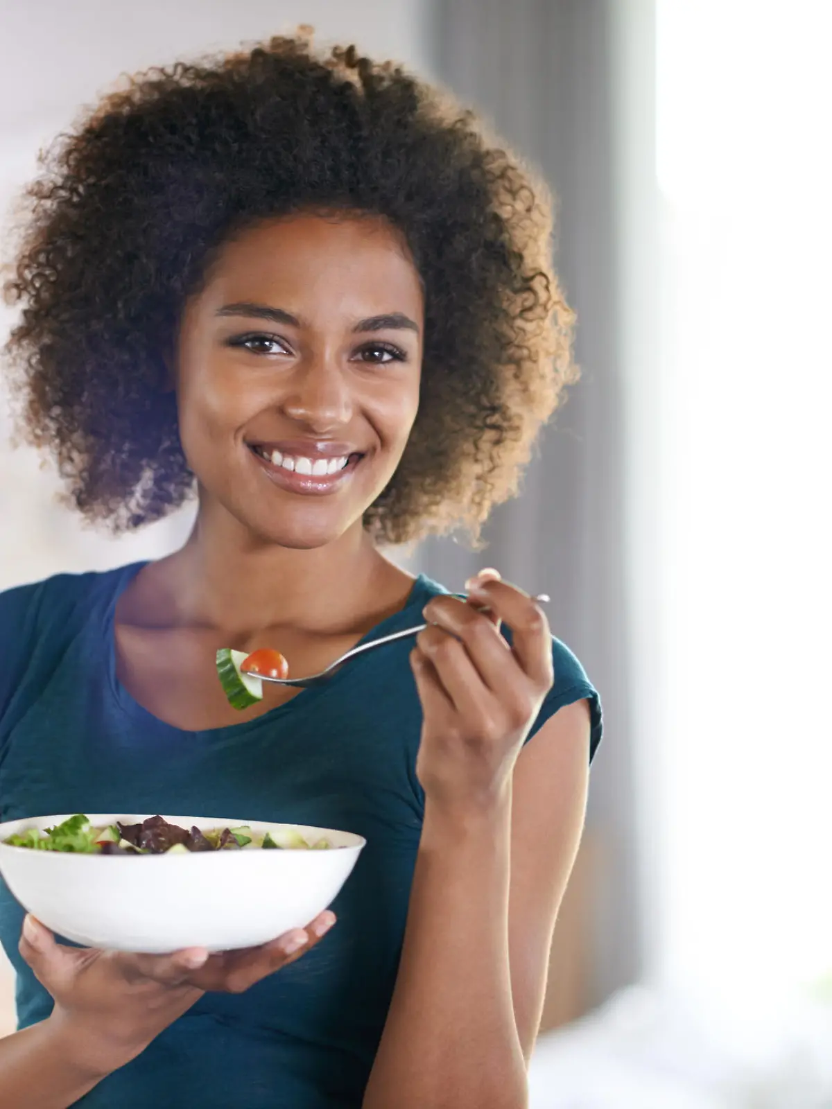 A beautiful young woman eating a bowl of salad at homehttp://195.154.178.81/DATA/shoots/ic_783564.jpg