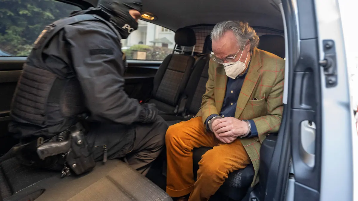 07.12.2022, Hessen, Frankfurt/Main: Bei einer Razzia gegen sogenannte «Reichsbürger» sitzt ein vermummter Polizist, nach der Durchsuchung eines Hauses, mit dem festgenommenen Heinrich XIII Prinz Reuß (r) in einem Polizeifahrzeug. Dieser trägt dabei Handschellen. Die Bundesanwaltschaft hat am Mittwochmorgen mehrere Menschen aus der sogenannten Reichsbürgerszene im Zuge einer Razzia festnehmen lassen. Zahlreiche Beamte seien in mehreren Bundesländern im Einsatz, sagte eine Sprecherin der Karlsruher Behörde . Foto: Boris Roessler/dpa +++ dpa-Bildfunk +++