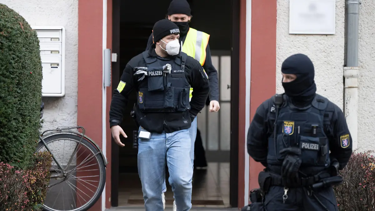 07.12.2022, Hessen, Frankfurt/Main: Bei einer Razzia gegen sogenannte «Reichsbürger» stehen Polizisten vor einem durchsuchten Objekt in Frankfurt. Die Bundesanwaltschaft hat am Mittwochmorgen mehrere Menschen aus der sogenannten Reichsbürgerszene im Zuge einer Razzia festnehmen lassen. Zahlreiche Beamte seien in mehreren Bundesländern im Einsatz, sagte eine Sprecherin der Karlsruher Behörde. Foto: Boris Roessler/dpa - ACHTUNG: Ein Schild wurde aus rechtlichen Gründen gepixelt +++ dpa-Bildfunk +++