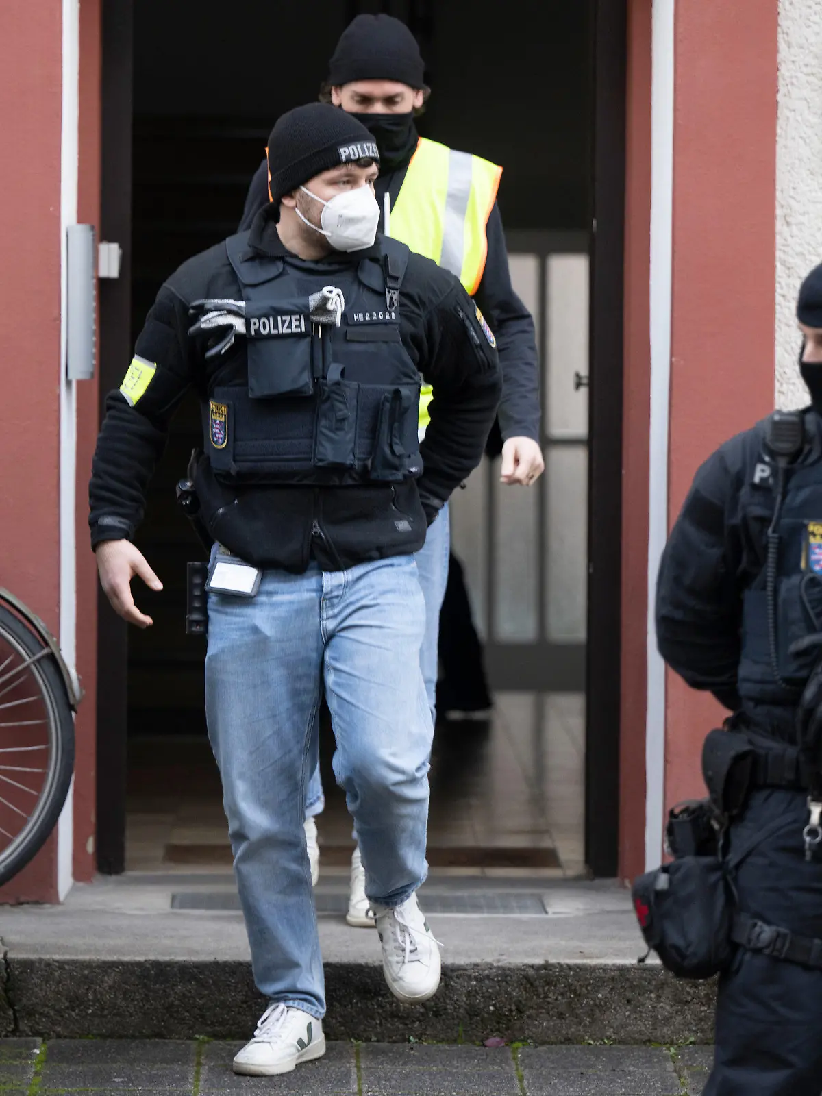 07.12.2022, Hessen, Frankfurt/Main: Bei einer Razzia gegen sogenannte «Reichsbürger» stehen Polizisten vor einem durchsuchten Objekt in Frankfurt. Die Bundesanwaltschaft hat am Mittwochmorgen mehrere Menschen aus der sogenannten Reichsbürgerszene im Zuge einer Razzia festnehmen lassen. Zahlreiche Beamte seien in mehreren Bundesländern im Einsatz, sagte eine Sprecherin der Karlsruher Behörde. Foto: Boris Roessler/dpa - ACHTUNG: Ein Schild wurde aus rechtlichen Gründen gepixelt +++ dpa-Bildfunk +++