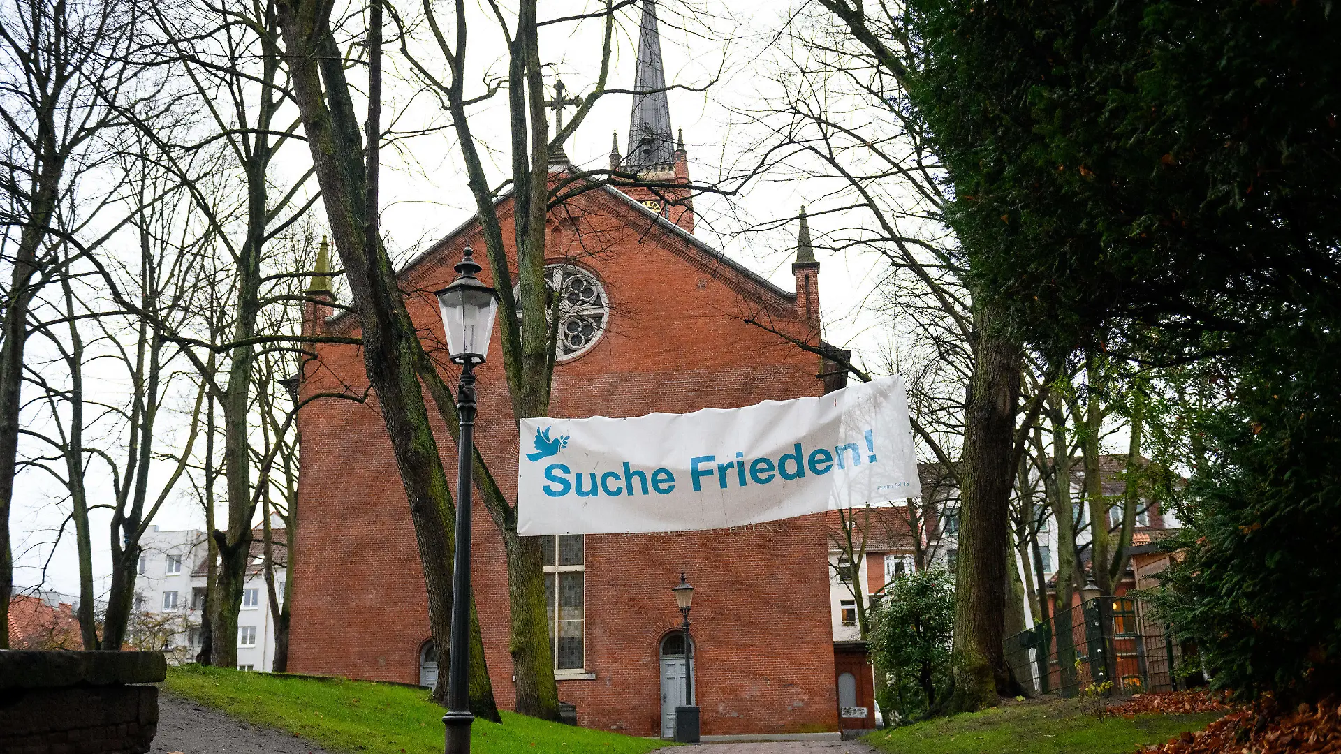 06.12.2022, Hamburg: "Suche Frieden" steht auf einem Banner auf dem Gelände vor dem Kirchengebäude. Die St. Pauli Kirche wird im Winter mit Blick auf die hohen Energiekosten für drei Monate geschlossen bleiben. Foto: Jonas Walzberg/dpa +++ dpa-Bildfunk +++