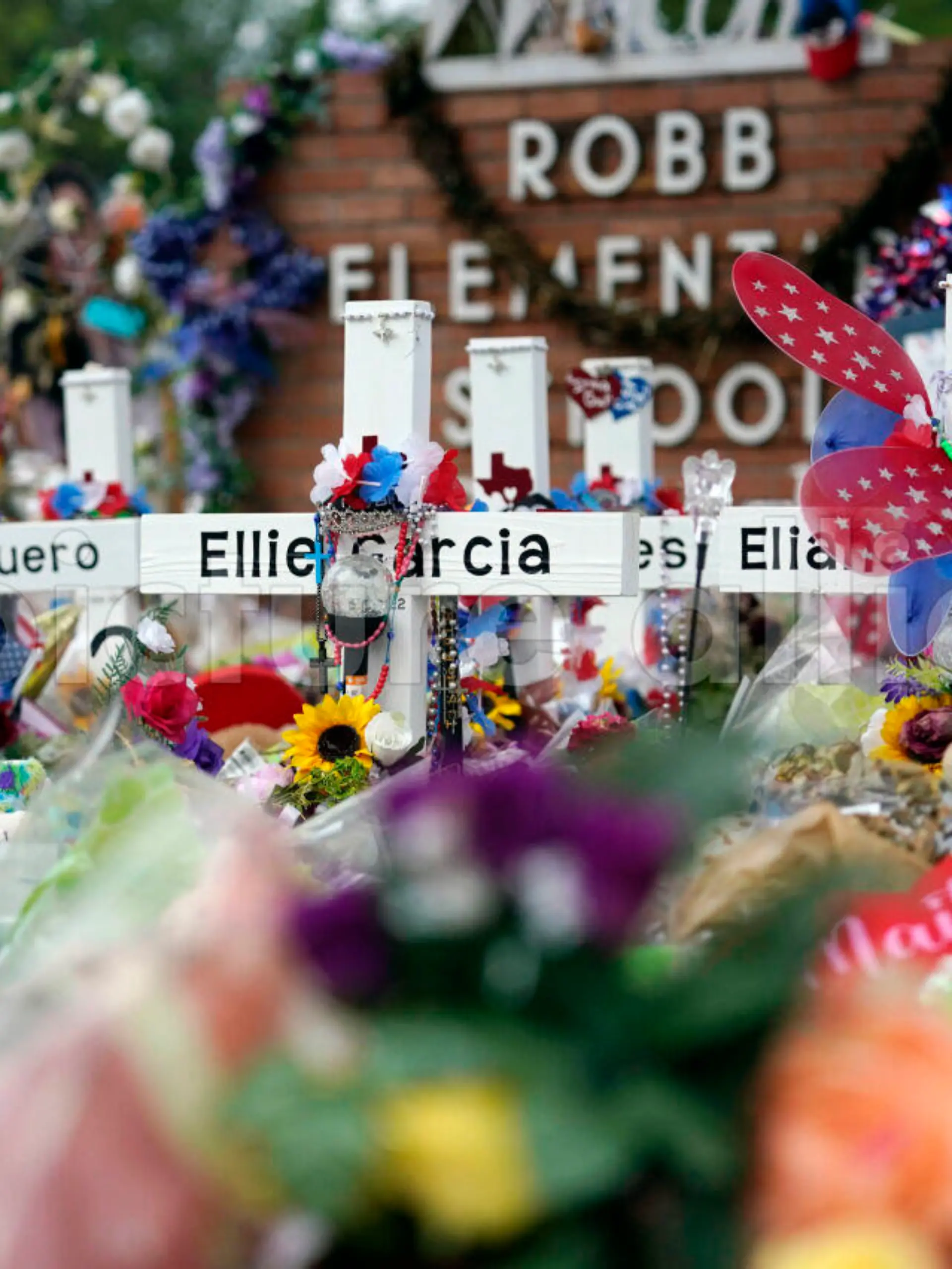 Crosses are surrounded by flowers and other items at a memorial at Robb Elementary School, Thursday, June 9, 2022, in Uvalde, Texas, created to honor the victims killed in the recent school shooting. Two teachers and 19 students were killed in the mass shooting. (AP Photo/Eric Gay)