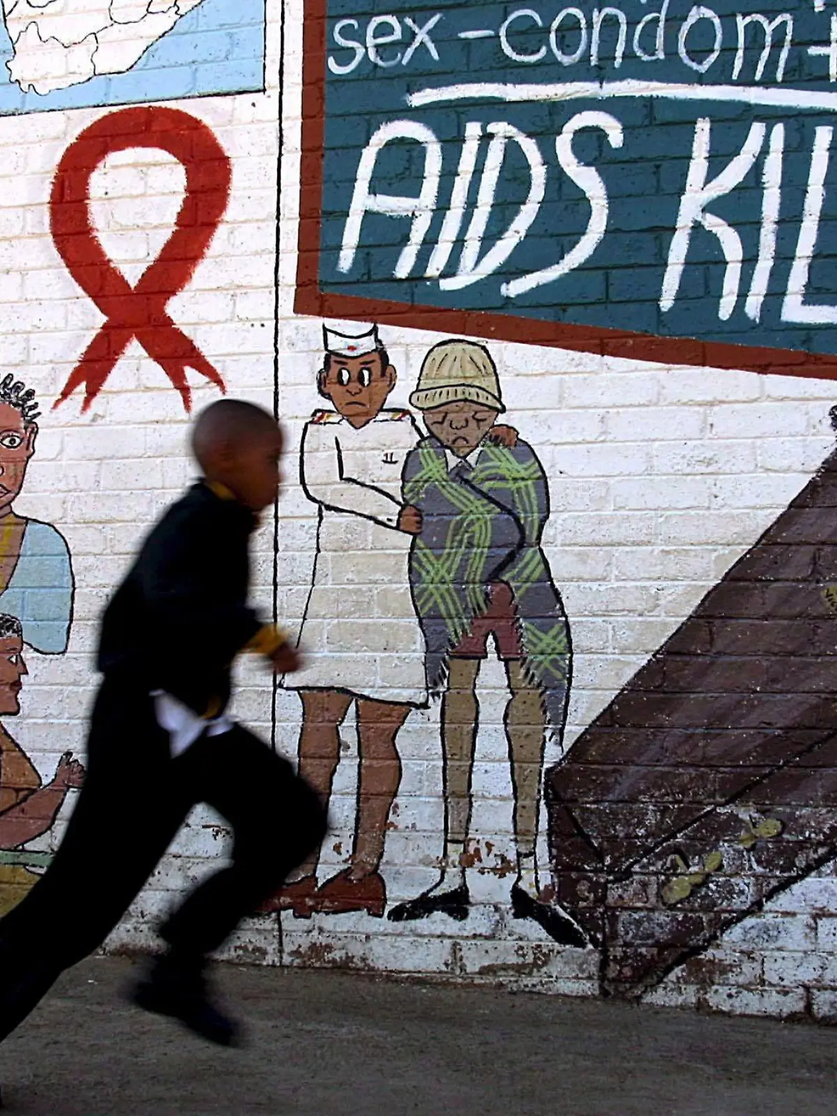 ARCHIV - Ein Schuljunge rennt in Soweto in Johannesburg an einem Wandbild vorbei, das vor Aids warnt (Archivfoto vom 17.05.2002). Am 1. Dezember ist Weltaidstag. Nach Schätzungen des Aidsprogramms der Vereinten Nationen UNAIDS gibt es weltweit 34 Millionen Infizierte, täglich kommen 7400 dazu. In Deutschland leben rund 70 000 Menschen mit HIV. Die Zahl der Neuinfektionen in der Bundesrepublik lag Ende 2010 bei 3000, etwa 550 Infizierte starben. Foto: Kim Ludbrook  +++(c) dpa - Bildfunk+++