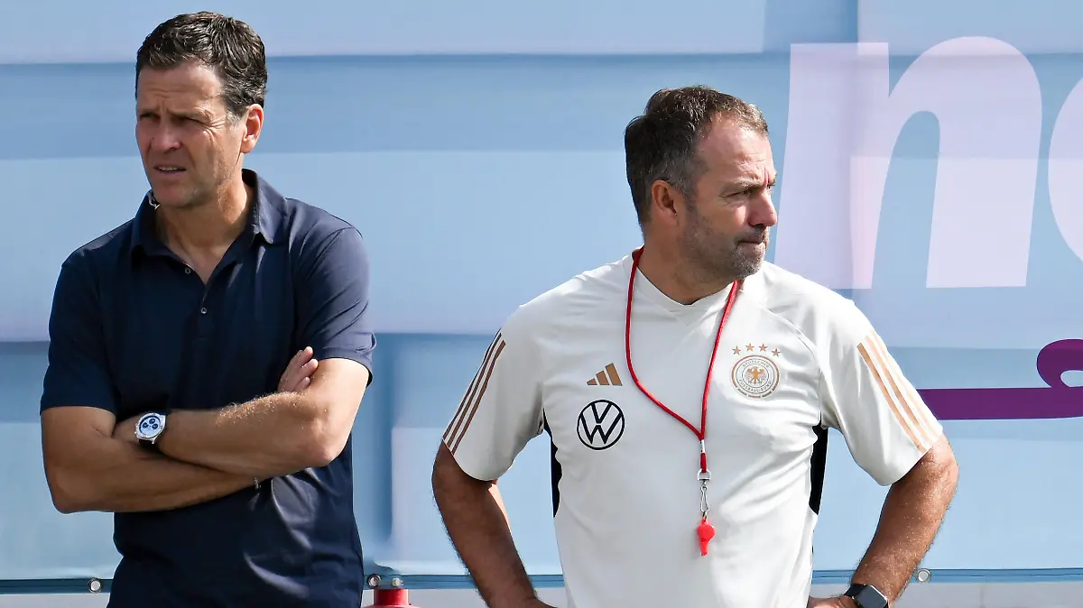 19.11.2022, Katar, Madinat Ash-Shamal: Vorbereitung auf die WM in Katar, Nationalmannschaft Deutschland, Training im Al-Shamal Stadion, Deutschlands Oliver Bierhoff, damaliger Geschäftsführer Nationalmannschaften und Akademie, (l) und Bundestrainer Hansi Flick während des Trainings. Bierhoff hat seinen Vertrag beim Deutschen Fußball-Bund vorzeitig aufgelöst. (zu dpa: Nach WM-Aus: Bierhoff und DFB lösen Vertrag auf) Foto: Federico Gambarini/dpa +++ dpa-Bildfunk +++