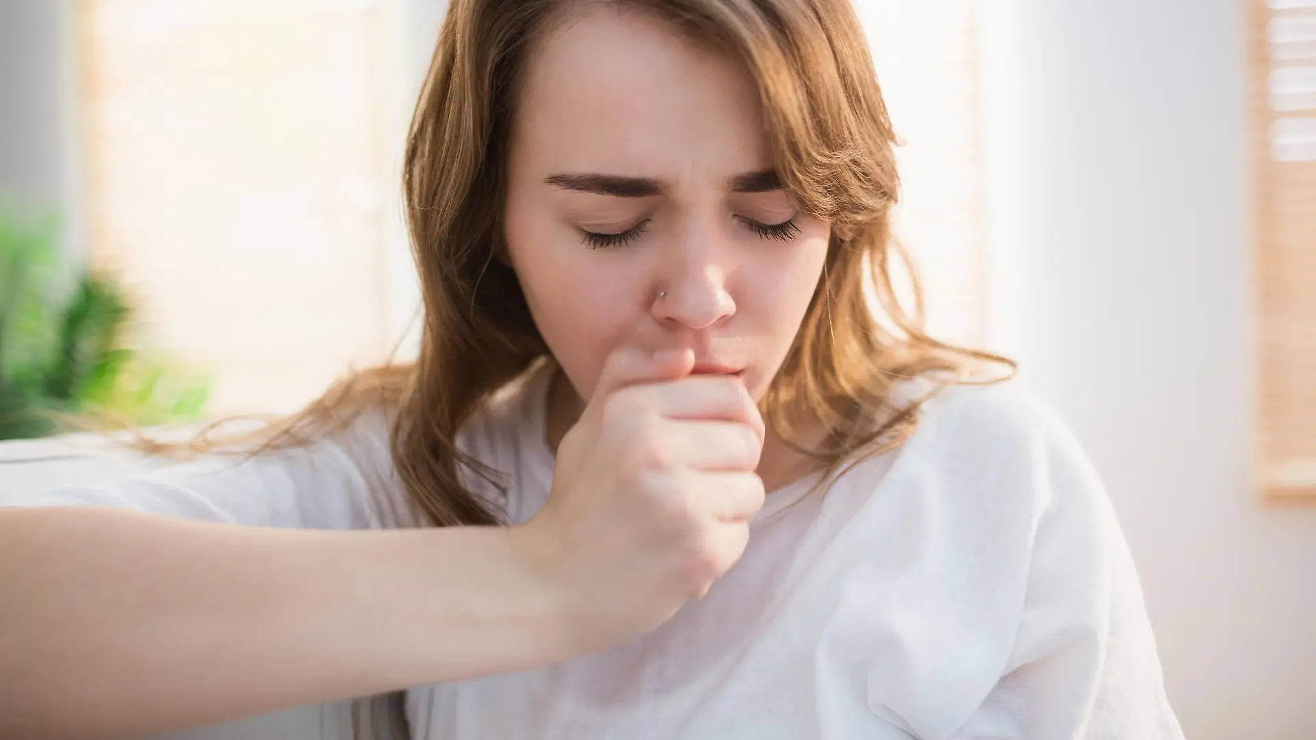 Pretty woman coughing in the living room