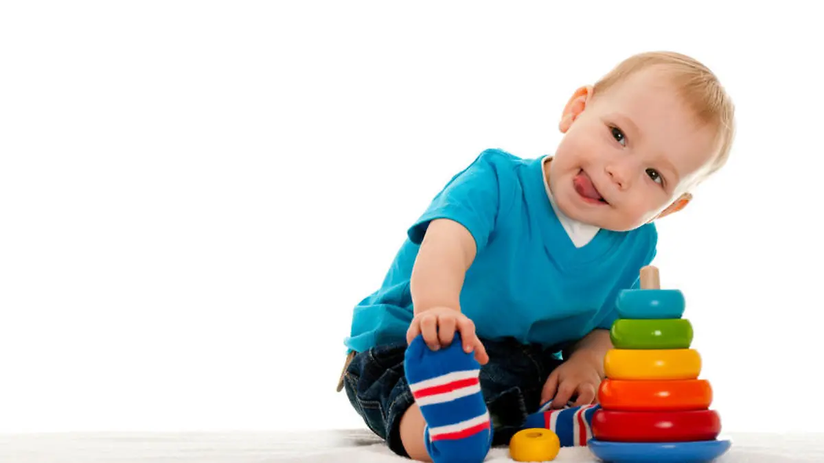 A little boy is playing with toys on the blanket; isolated on the white background