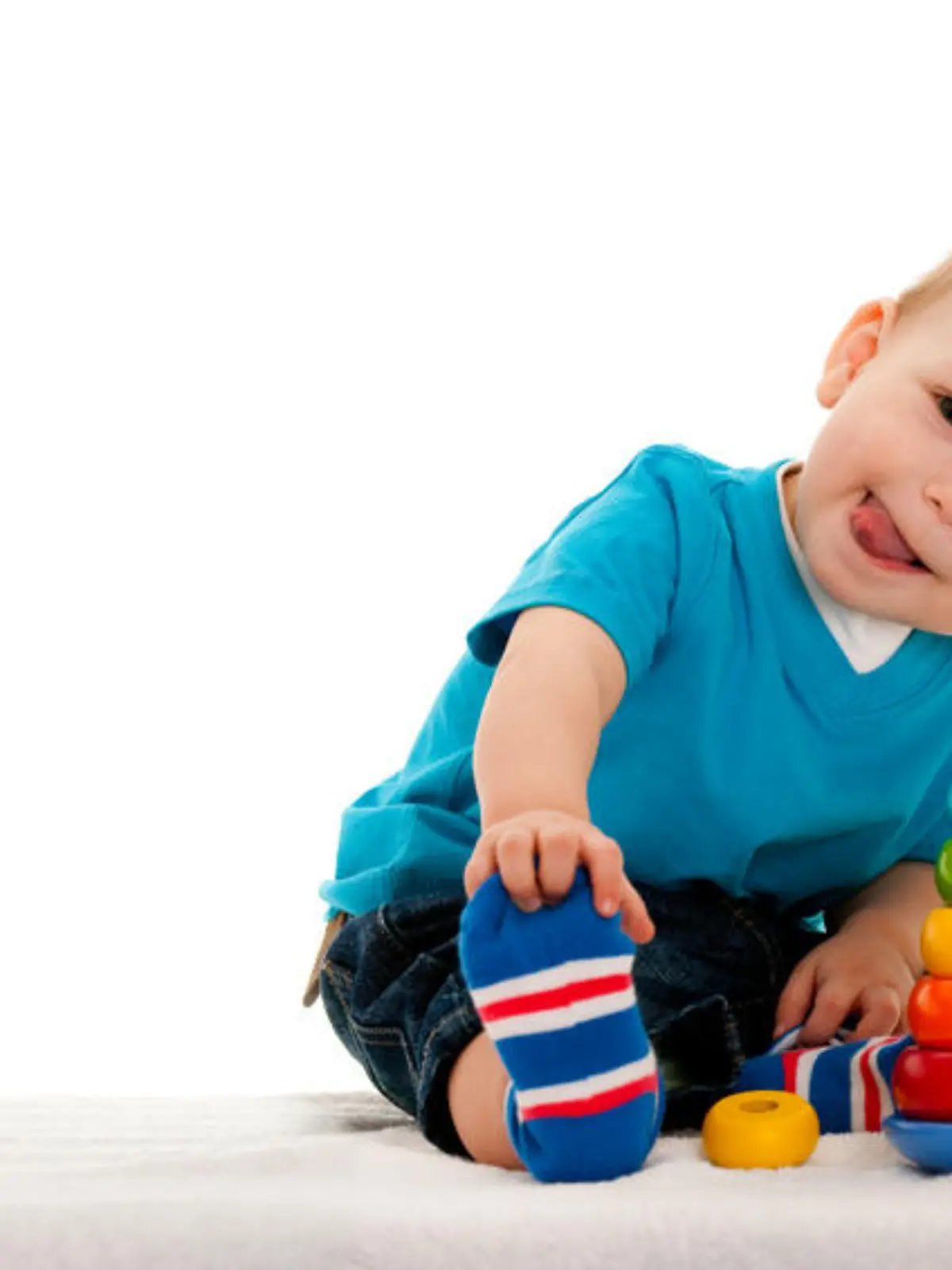 A little boy is playing with toys on the blanket; isolated on the white background