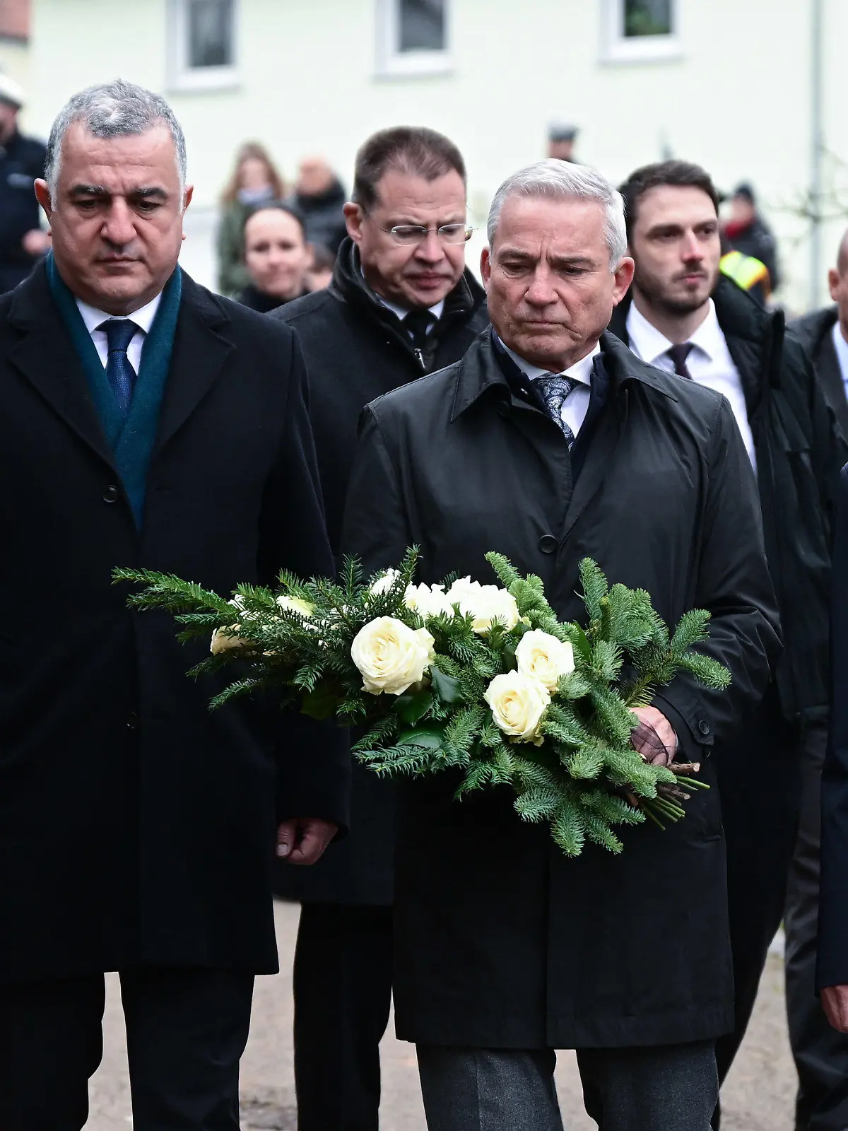 06.12.2022, Baden-Württemberg, Illerkirchberg: Thomas Strobl (M, CDU), Innenminister von Baden-Württemberg, und Ahmet Basar Sen (l), Botschafter der Türkei in Deutschland, legen am Tatort eines Messerangriffs auf zwei Mädchen bei einer Schweigeminute einen Kranz nieder. Foto: Bernd Weißbrod/dpa +++ dpa-Bildfunk +++