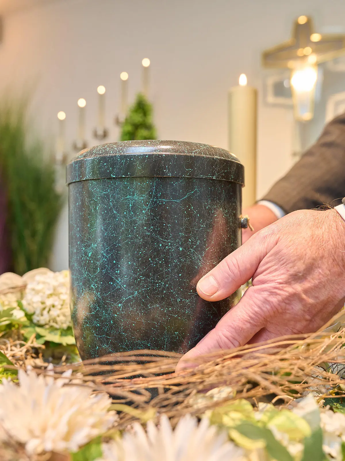 PRODUKTION - 24.10.2022, Rheinland-Pfalz, Dachsenhausen: Bestatter Udo Feller platziert eine Urne im Andachtsraum des Krematoriums Dachsenhausen. Beim Blick auf den eigenen Tod geben sich 80 Prozent der Erwachsenen in Deutschland bescheiden. Das bringt eine repräsentative Umfrage des Meinungsforschungsinstituts YouGov im Auftrag der Deutschen Presse-Agentur ans Licht. (zu dpa: «Umfrage: 80 Prozent wollen für sich nur kleine oder keine Trauerfeier») Foto: Thomas Frey/dpa +++ dpa-Bildfunk +++