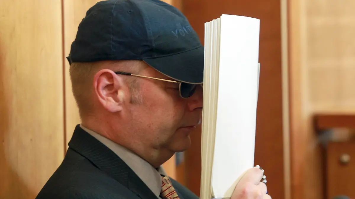 Defendant Olaf H. covers his face as he sits before his trial in the regional court in Krefeld, July 12, 2011. The trial of Olaf H., accused of killing 10-year old Mirco S., who went missing since September 3, 2010 and was found after 146 days of searches, opened on Tuesday. REUTERS/Roland Weihrauch (GERMANY - Tags: CRIME LAW)