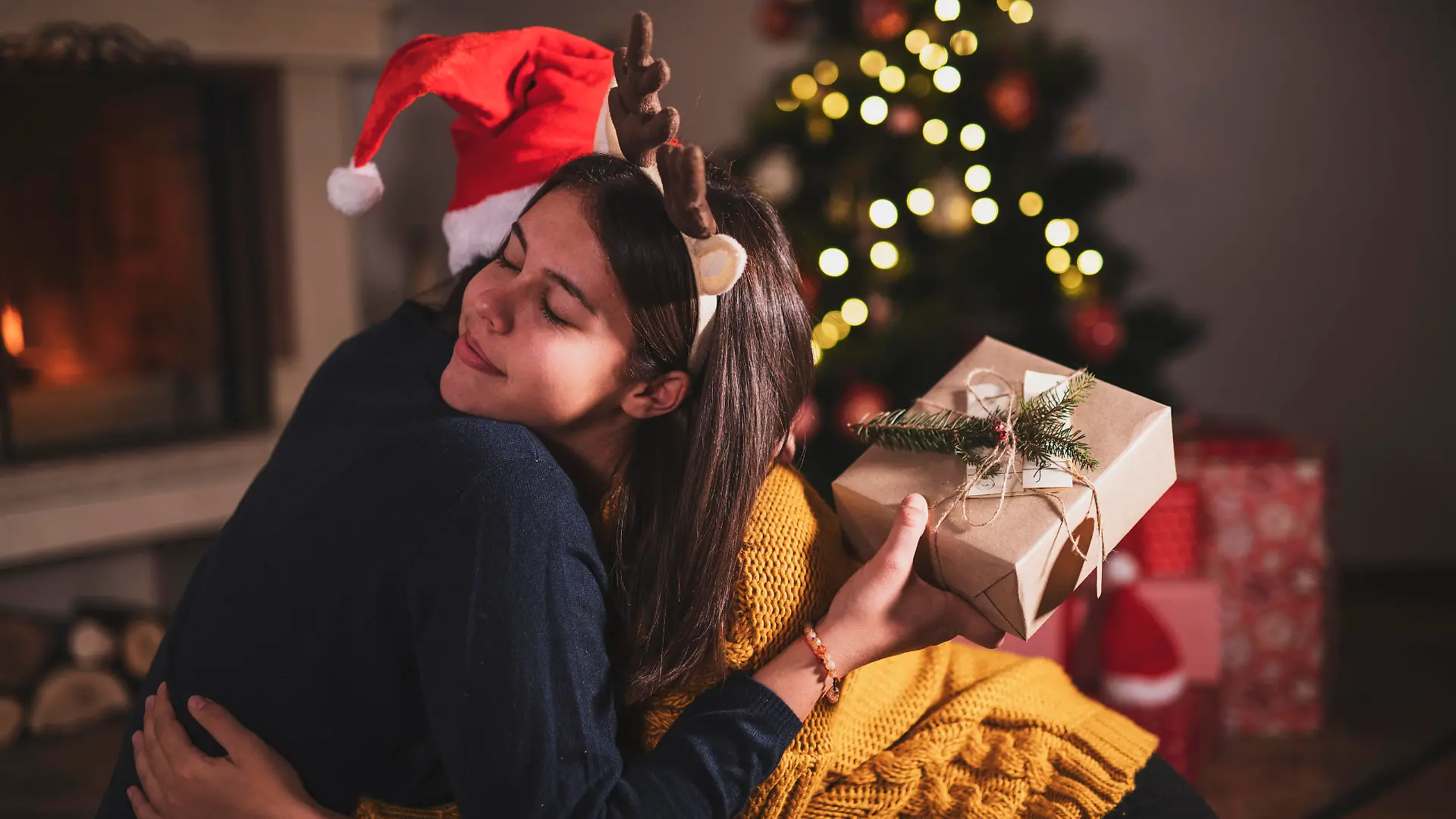 Sisters hugging during opening Christmas presents.
