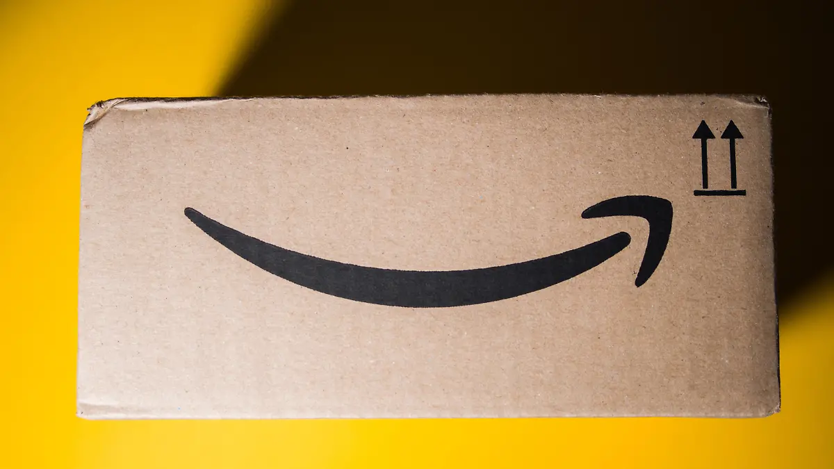 PARIS, FRANCE - SEP 28, 2018: Directly above view of New Amazon Cardboard box against yellow background. Amazon Prime is the online paid subscription service offered by Amazon.com web-commerce site