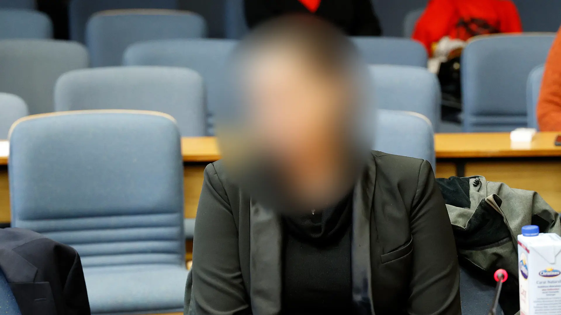 05.12.2022, Bayern, Traunstein: Eine von zwei Angeklagten wartet im Saal des Traunsteiner Landgerichts. Die Anklagebehörde wirft Mutter und Tochter vor, sie hätten gemeinsam beschlossen, ihren 75 Jahre alten Vater beziehungsweise Großvater zu töten. Foto: Uwe Lein/dpa - ACHTUNG: Die Angeklagte wurde aus rechtlichen Gründen gepixelt +++ dpa-Bildfunk +++