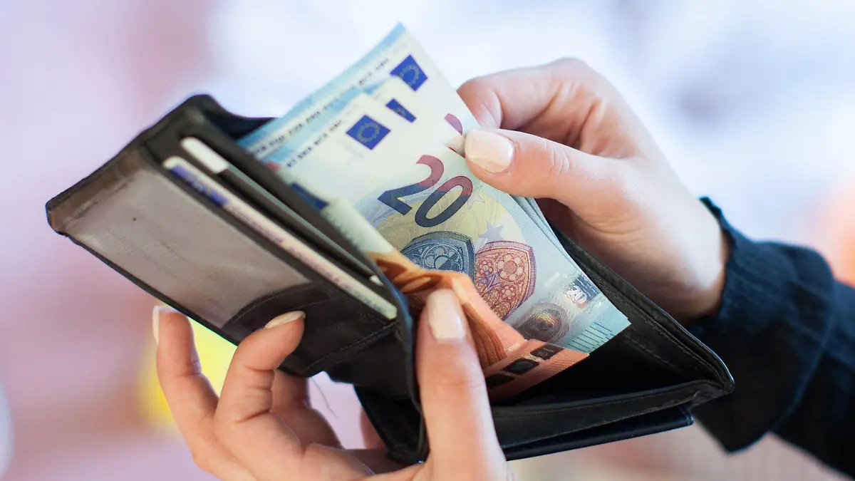 ARCHIV - 25.05.2016, Berlin: ILLUSTRATION - Eine Frau nimmt Banknoten aus einem Geldbeutel. Der Vermittlungsausschuss von Bundestag und Bundesrat soll am kommenden Mittwoch einen Kompromiss im Streit um das geplante Bürgergeld finden. Foto: Christin Klose/dpa +++ dpa-Bildfunk +++