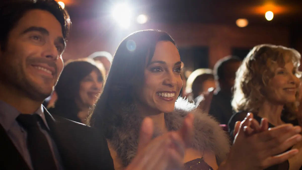 Personen im Theater applaudierend beim Musical schauen