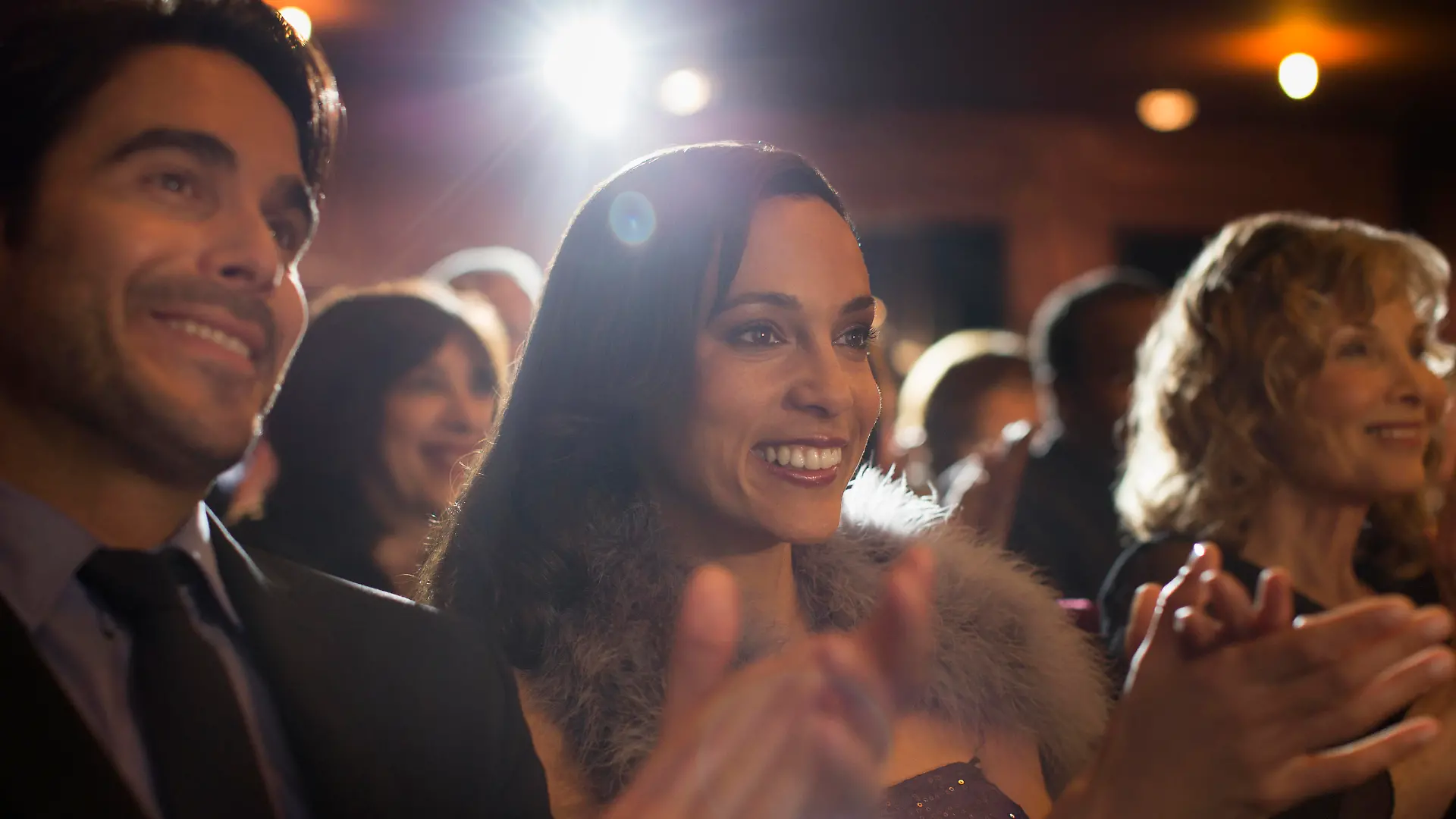 Personen im Theater applaudierend beim Musical schauen