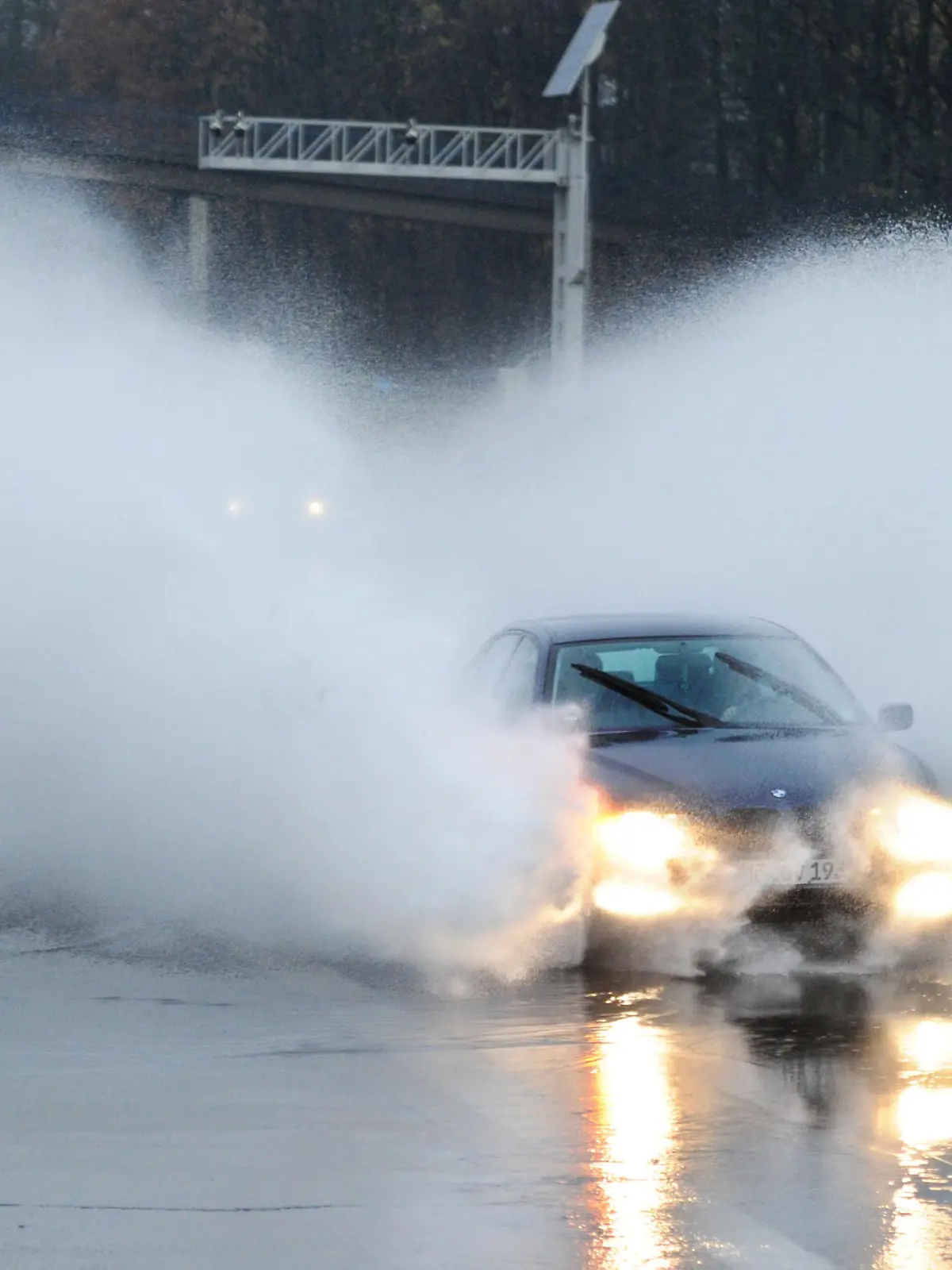 Ein Auto fährt am Samstag (13.11.2010) mit hoher Geschwindigkeit durch eine überflutete Autobahnabfahrt der Autobahn 52 im Süden von Essen. Anhaltender Regen hat am Samstagmorgen im Ruhrgebiet zu zahlreichen überfluteten Straßen geführt. Im Essener Stadtgebiet verzeichnete die Polizei nach Angaben eines Sprechers allein zwischen 6.00 und 8.00 Uhr rund 250 Einsätze wegen überschwemmter Straßen. Foto: Julian Stratenschulte dpa/lnw