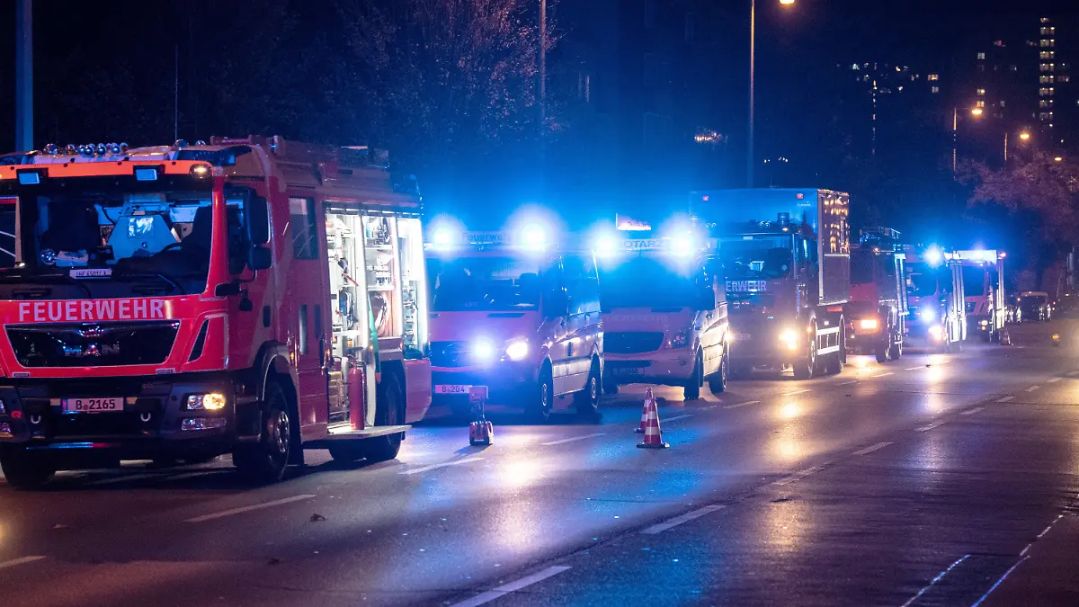 03.11.2022, Berlin: Einsatzfahrzeuge der Feuerwehr und Krankenwagen stehen an einem Gebäude in Berlin-Friedrichsfelde. Dort war am Abend ein Feuer in einer Wohnung in der dritten Etage des elfgeschossigen Gebäudes ausgebrochen. Das Feuer breitete sich dann schnell auf das vierte Obergeschoss aus. Über 90 Einsatzkräfte der Feuerwehr sowie zahlreiche Rettungskräfte waren im Einsatz. Nach ersten Informationen wurden elf Bewohner verletzt, einer starb trotz Reanimation noch vor Ort. Foto: Paul Zinken/dpa +++ dpa-Bildfunk +++