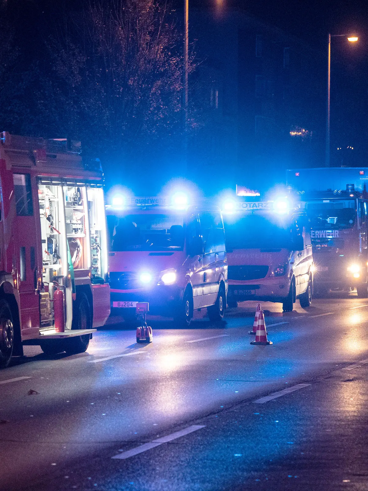 03.11.2022, Berlin: Einsatzfahrzeuge der Feuerwehr und Krankenwagen stehen an einem Gebäude in Berlin-Friedrichsfelde. Dort war am Abend ein Feuer in einer Wohnung in der dritten Etage des elfgeschossigen Gebäudes ausgebrochen. Das Feuer breitete sich dann schnell auf das vierte Obergeschoss aus. Über 90 Einsatzkräfte der Feuerwehr sowie zahlreiche Rettungskräfte waren im Einsatz. Nach ersten Informationen wurden elf Bewohner verletzt, einer starb trotz Reanimation noch vor Ort. Foto: Paul Zinken/dpa +++ dpa-Bildfunk +++