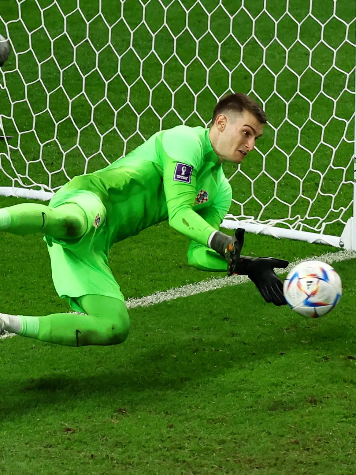 Soccer Football - FIFA World Cup Qatar 2022 - Round of 16 - Japan v Croatia - Al Janoub Stadium, Al Wakrah, Qatar - December 5, 2022 Croatia's Dominik Livakovic saves a penalty from Japan's Takumi Minamino during the shootout REUTERS/Lee Smith