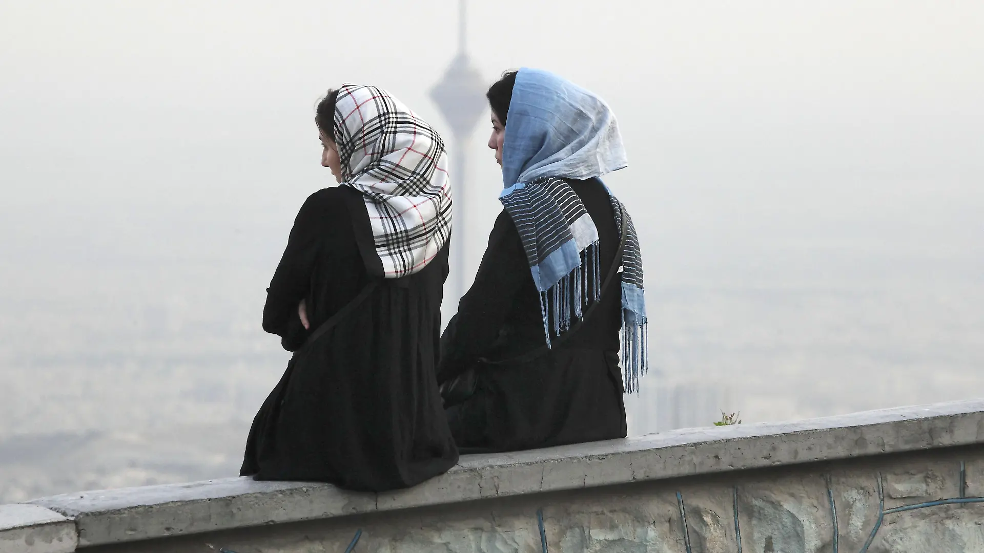 Teheran, Iran,28.07.2012 JE - Zwei junge iranische Frauen unterhalten sich in Teheran, Milad Tower im Hintergrund. | Verwendung weltweit