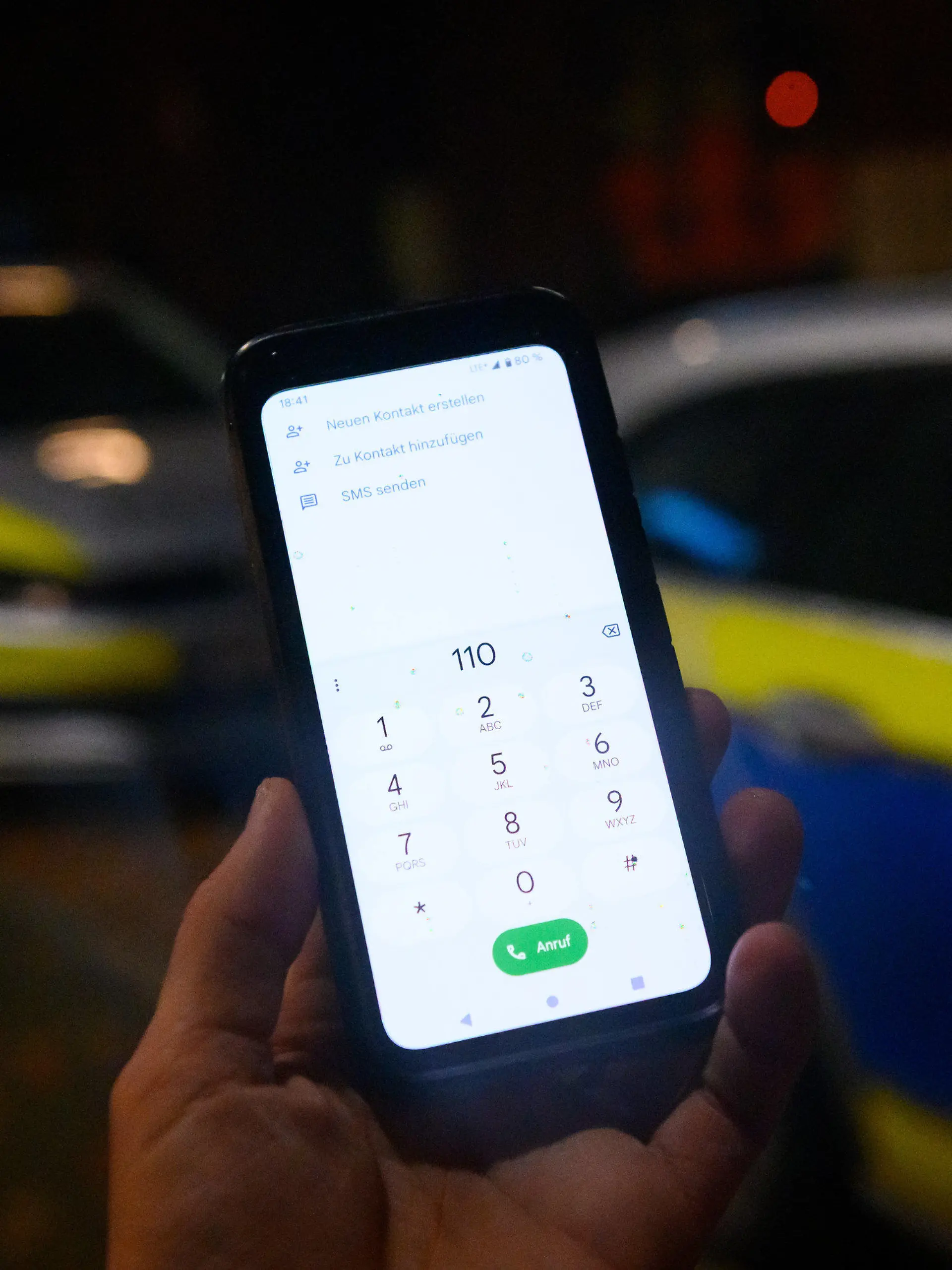 ILLUSTRATION - 17.11.2022, Hamburg: Die Notrufnummer "110" ist auf einem Smartphone eingegeben, dass vor zwei Streifenwagen gehalten wird. Wegen Störungen im Mobilfunknetz haben die Behörden in Berlin, Bremen und Hamburg am 17.11.2022 verstärkt Hinweise bekommen, dass der Notruf nicht zu erreichen sei. Foto: Jonas Walzberg/dpa +++ dpa-Bildfunk +++