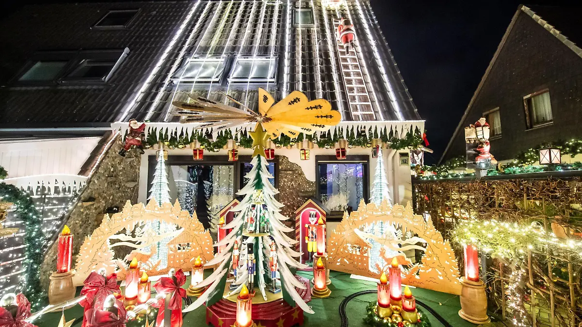 23.11.2021, Niedersachsen, Delmenhorst: Ein weihnachtlich geschmücktes Haus leuchtet im Dunklen. Lange hat die Familie Borchart gebastelt und geschmückt. Nun ist ihr Haus bis in die Dachspitze hinein mit Lichtern versehen. Foto: Sina Schuldt/dpa +++ dpa-Bildfunk +++