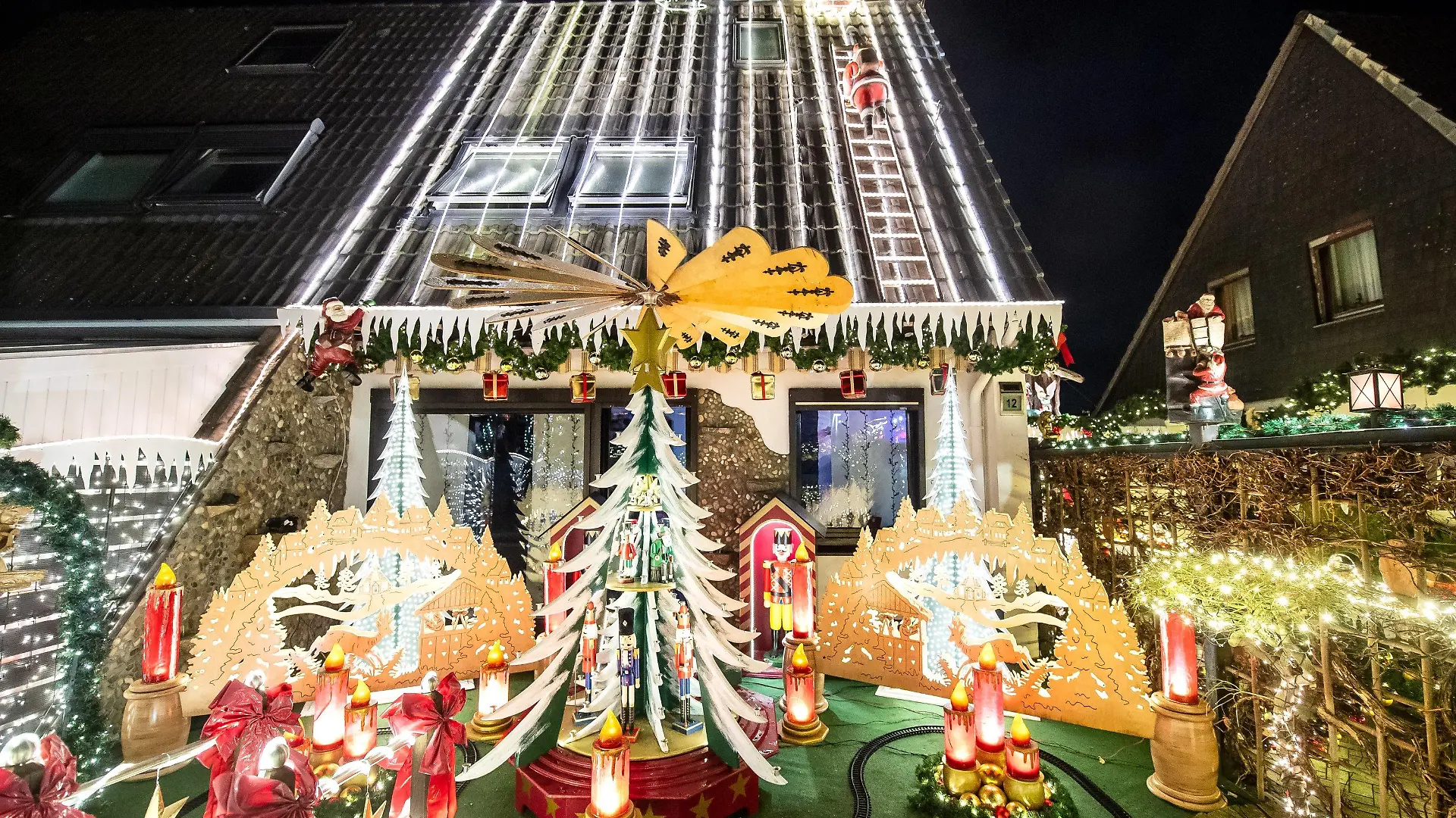 23.11.2021, Niedersachsen, Delmenhorst: Ein weihnachtlich geschmücktes Haus leuchtet im Dunklen. Lange hat die Familie Borchart gebastelt und geschmückt. Nun ist ihr Haus bis in die Dachspitze hinein mit Lichtern versehen. Foto: Sina Schuldt/dpa +++ dpa-Bildfunk +++