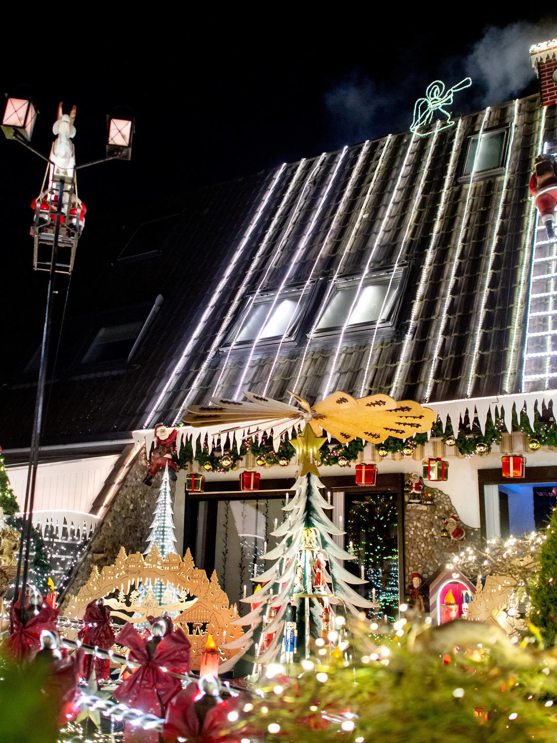 PRODUKTION - 24.11.2022, Niedersachsen, Delmenhorst: Zahlreiche Lichter erstrahlen am weihnachtlich geschmückten Haus der Familie Borchart. Vom 1. Advent bis zum Jahresende erstrahlt das Haus der Familie mit Weihnachtsdekoration und rund 60.000 Lichtern. Foto: Hauke-Christian Dittrich/dpa +++ dpa-Bildfunk +++