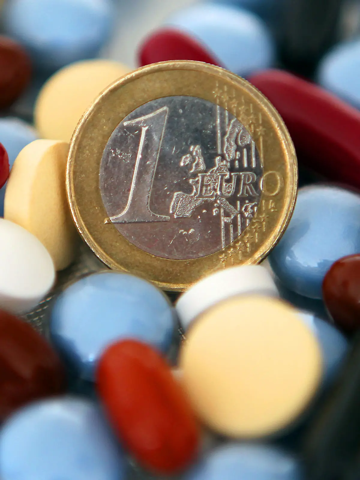 ARCHIV - ILLUSTRATION - Verschiedene Tabletten liegen am 11.03.2010 um eine Euro-Münze herum. Trotz der Gesundheitsreform müssen sich die Bürger nach Darstellung von Bundesgesundheitsminister Philipp Rösler (FDP) auf steigende Kosten für die medizinische Versorgung einstellen. An diesem Freitag soll der Bundestag die künftige Finanzierung der gesetzlichen Krankenversicherung verabschieden. Danach werden 2011 die Beiträge von 14,9 auf 15,5 Prozent steigen. Schon heute am Donnerstag (11.11.2010) will die Koalition ein Gesetz zur Begrenzung der Pharma-Ausgaben durch den Bundestag bringen. Foto: Oliver Berg dpa  +++(c) dpa - Bildfunk+++