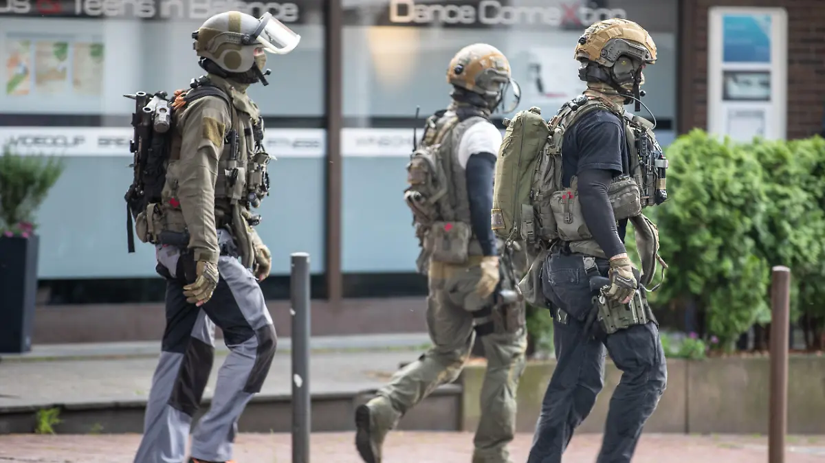 16.05.2022, Nordrhein-Westfalen, Essen: Drei Beamte eines Spezialeinsatzkommandos gehen in der Nähe ihres Einsatz im Zusammenhang mit dem vereitelten mutmaßlichen Terroranschlag in einem Essener Gymnasium, bei dem eine Person kurzzeitig festgenommen worden ist. Er befinde sich mittlerweile wieder auf freiem Fuß, sagte am Dienstag ein Sprecher der Essener Polizei. Der junge Erwachsene werde verdächtig, gegen das Waffengesetz verstoßen zu haben. Foto: Justin Brosch/dpa +++ dpa-Bildfunk +++