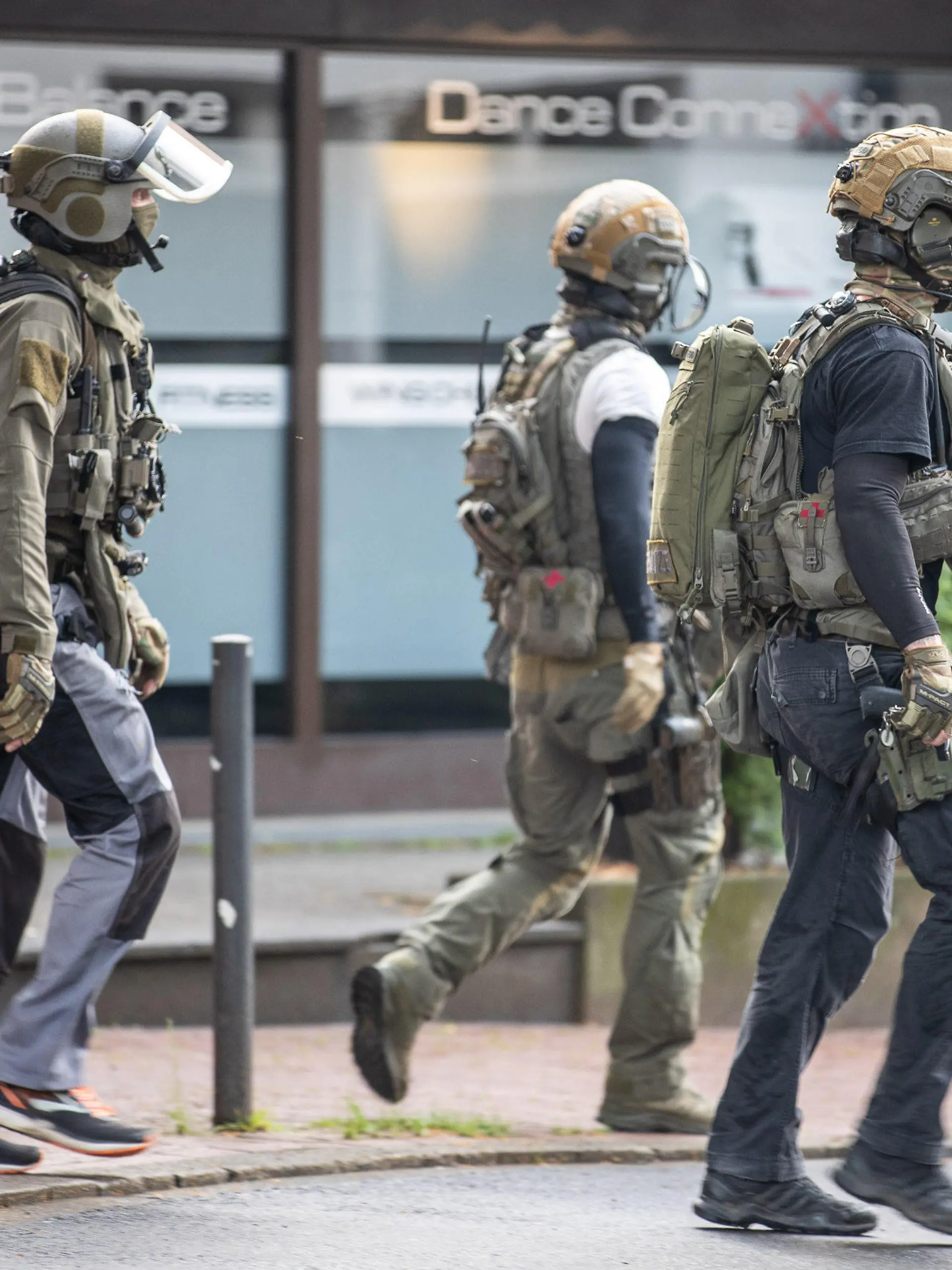 16.05.2022, Nordrhein-Westfalen, Essen: Drei Beamte eines Spezialeinsatzkommandos gehen in der Nähe ihres Einsatz im Zusammenhang mit dem vereitelten mutmaßlichen Terroranschlag in einem Essener Gymnasium, bei dem eine Person kurzzeitig festgenommen worden ist. Er befinde sich mittlerweile wieder auf freiem Fuß, sagte am Dienstag ein Sprecher der Essener Polizei. Der junge Erwachsene werde verdächtig, gegen das Waffengesetz verstoßen zu haben. Foto: Justin Brosch/dpa +++ dpa-Bildfunk +++
