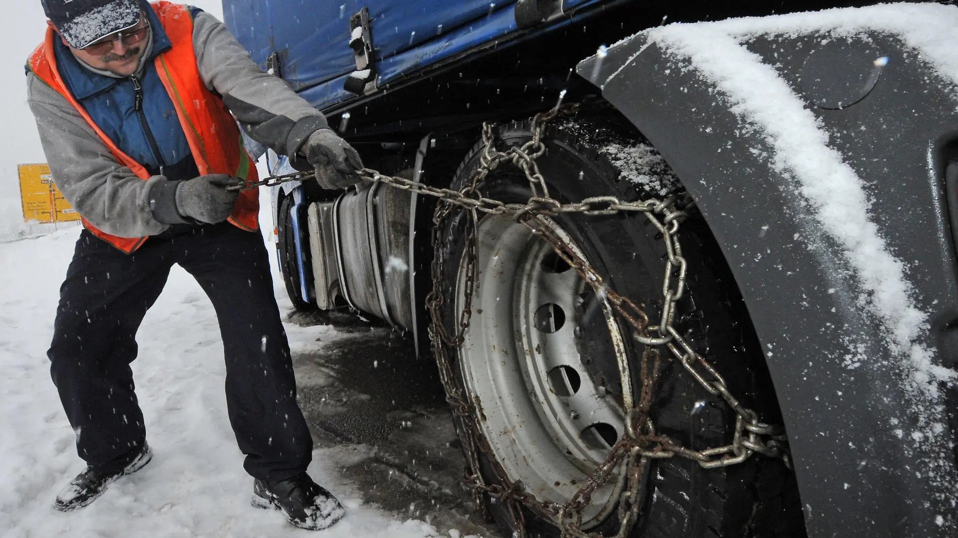 Ein polnischer Lkw-Fahrer zieht am Montag (06.12.2010) auf der B317 am Feldberg Schneeketten auf den Reifen seines Lkws auf. Starker Schneefall führt im Hochschwarzwald zu Behinderungen. Foto: Patrick Seeger dpa/lsw +++(c) dpa - Bildfunk+++