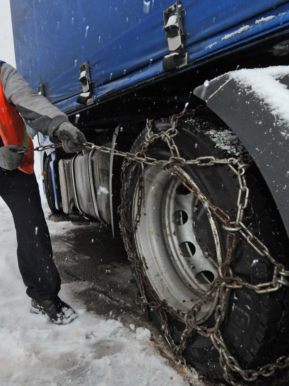 Ein polnischer Lkw-Fahrer zieht am Montag (06.12.2010) auf der B317 am Feldberg Schneeketten auf den Reifen seines Lkws auf. Starker Schneefall führt im Hochschwarzwald zu Behinderungen. Foto: Patrick Seeger dpa/lsw  +++(c) dpa - Bildfunk+++
