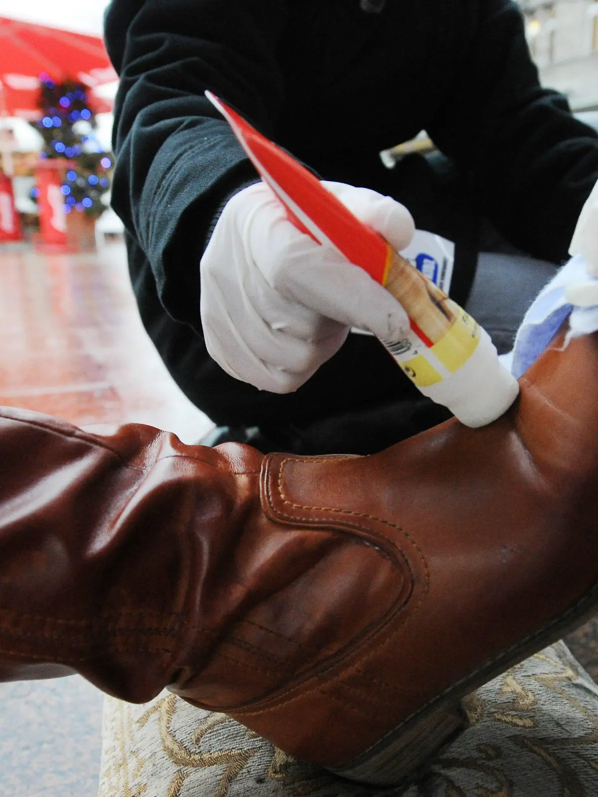 Schüler putzen am Mittwoch (24.11.2010) in Berlin mit Schuputzcreme und Lappen einen Lederstiefel. Schüler der Finow-Grundschule Berlin putzten vor dem KaDeWe Schuhe und Stiefel von Passanten und sammelten somit im Rahmen der bundesweiten Aktion der Kindernothilfe "Action!Kidz - Kinder gegen Kinderarbeit" Geld für notleidende Kinder in Haiti. Gleichzeitig lernten die Kinder höfliche Umgangsformen und auch die Überwindung von Scheu, so die Lehrerin. Foto: Tobias Kleinschmidt dpa/lbn  +++(c) dpa - Bildfunk+++