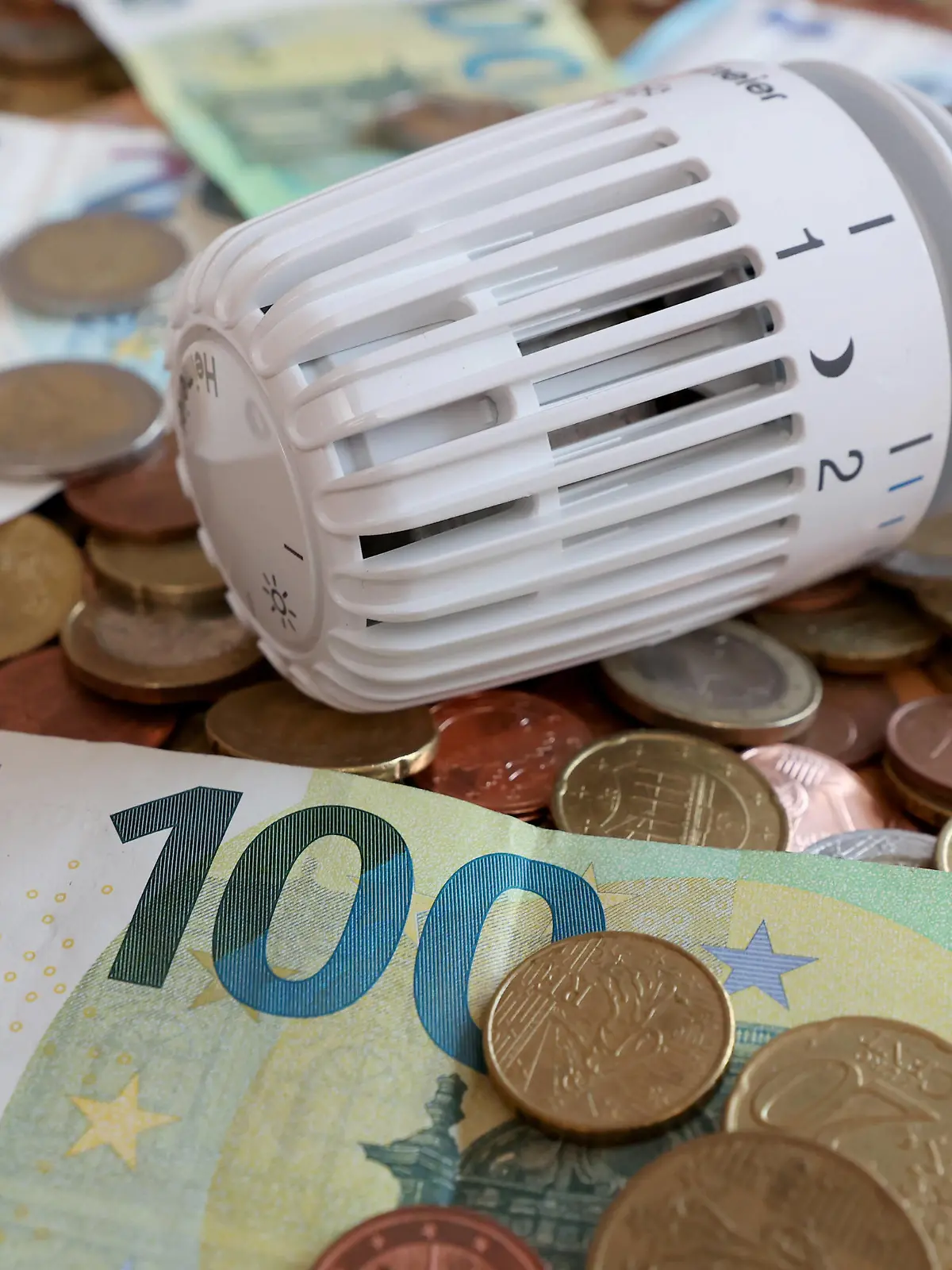  Gasumlage kommt. Gaspreisexplosion angesichts des Krieges in der Ukraine. Thermostatkopf liegt zwischen Euro Geldscheinen und Euromuenzen Euromünzen. Symbolbild zum Thema Energiekosten, Gaspreise, Gasumlage am 16.08.2022 in Siegen/Deutschland *** Gas levy comes gas price explosion in the face of war in Ukraine thermostat head lies between euro banknotes and euro coins euro coins symbol image on the subject of energy costs, gas prices, gas levy on 16 08 2022 in Siegen Germany