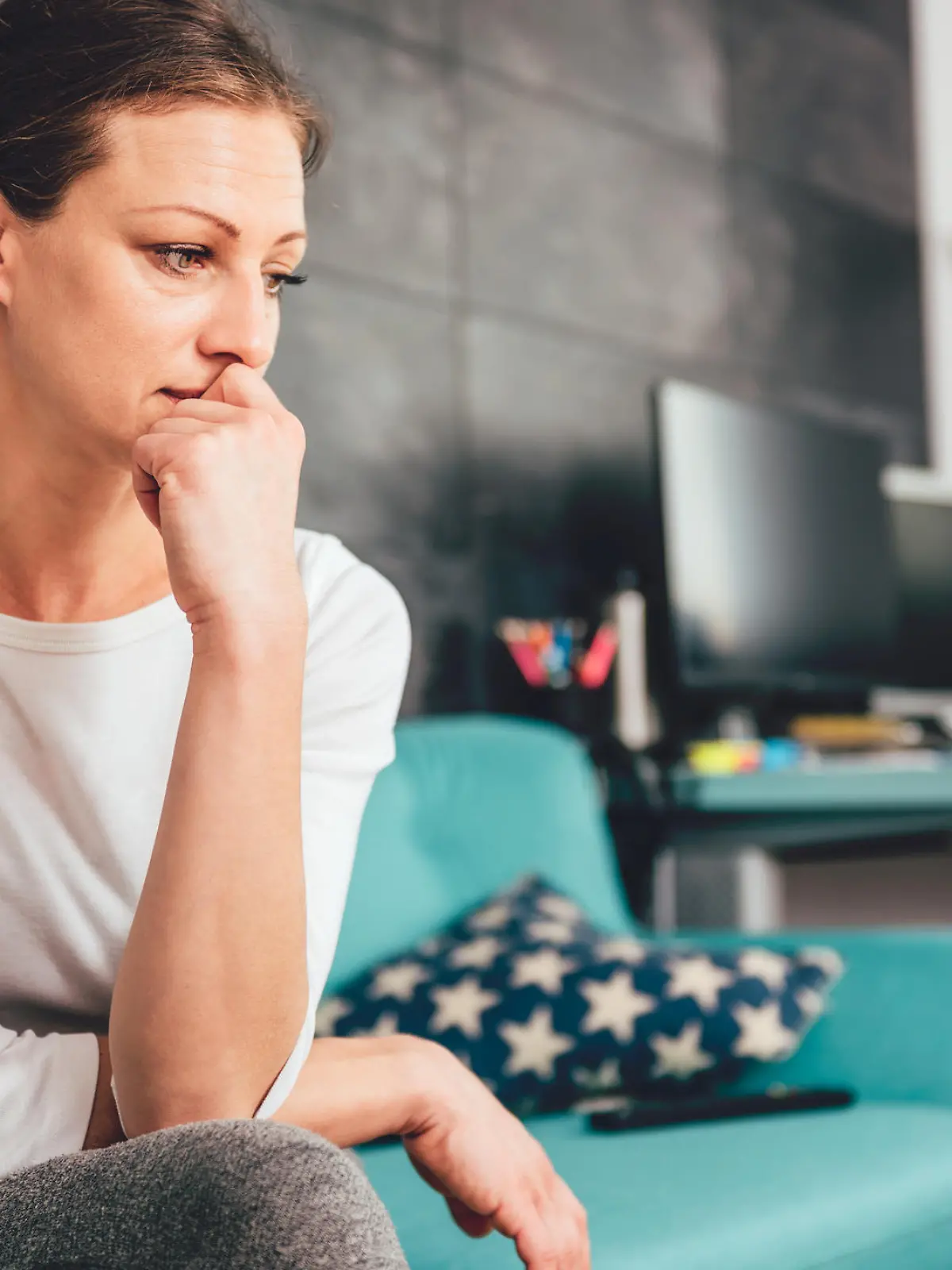 Sad woman sitting on a sofa in the living room