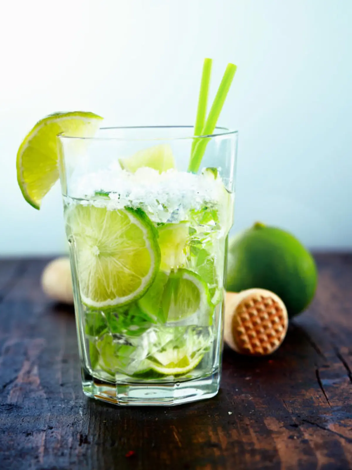 Refreshing cold Caipirinha with fresh lime slices and ice.