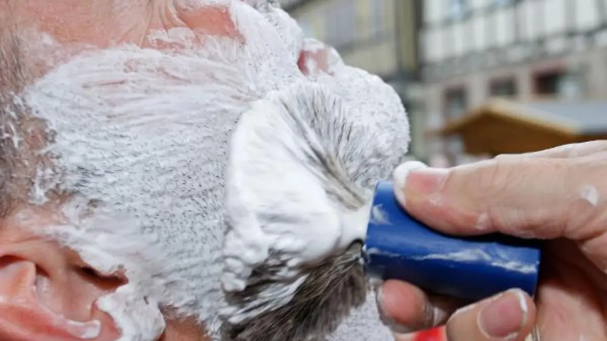Ein Model wird am Sonntag (20.07.2008) bei einem Wettrasieren in Buchen im Neckar-Odenwald-Kreis mit einem Pinsel eingeseift. Bei einem Wettkampf vor dem Alten Rathaus haben sich mehr als 160 Bartträger von sechs Barbieren öffentlich rasieren lassen. Der Wettbewerb erinnert an ein historisches Ereignis vor 150 Jahren. Damals wurde ein Buchener vom Großherzog von Baden zum «König der Barbiere» gekrönt. Der 18.000-Einwohner-Ort im Neckar-Odenwald-Kreis hofft, mit dem schnellsten Nassrasierer ins Buch der Rekorde zu kommen. Foto: Ronald Wittek dpa/lsw +++(c) dpa - Bildfunk+++